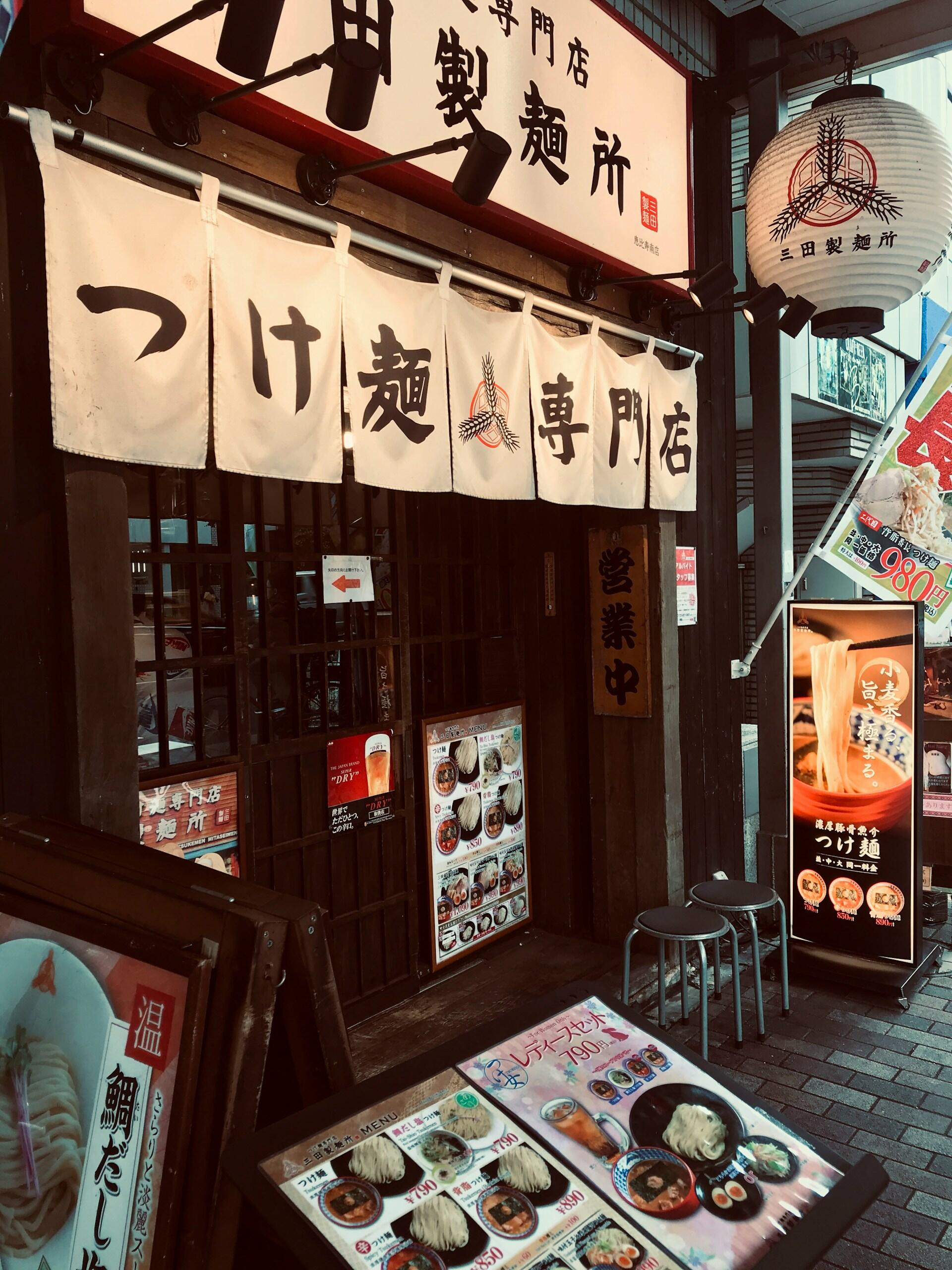 A shop front with Japanese characters strung above the doorway. 