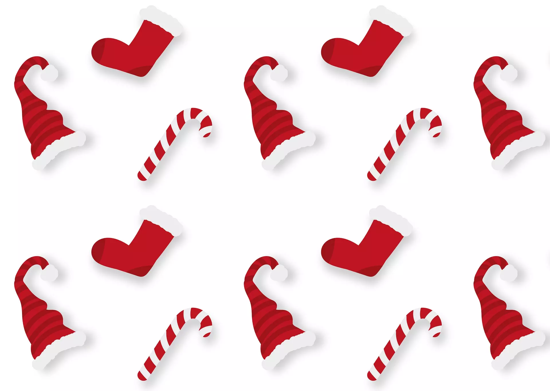 Pattern of red Christmas stockings and candy canes with Santa hats on white background.