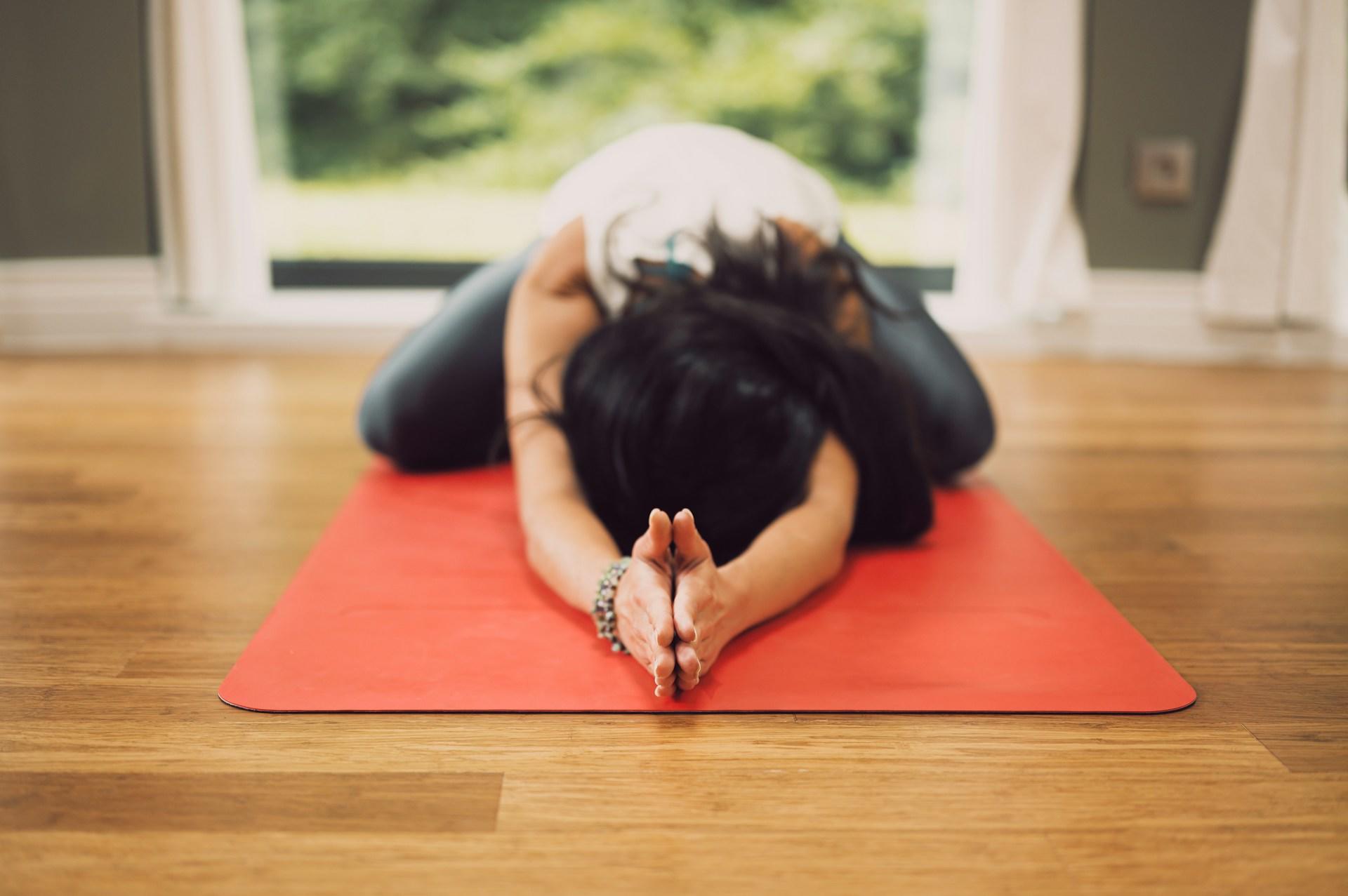 a person practising yoga on a red yoga mat