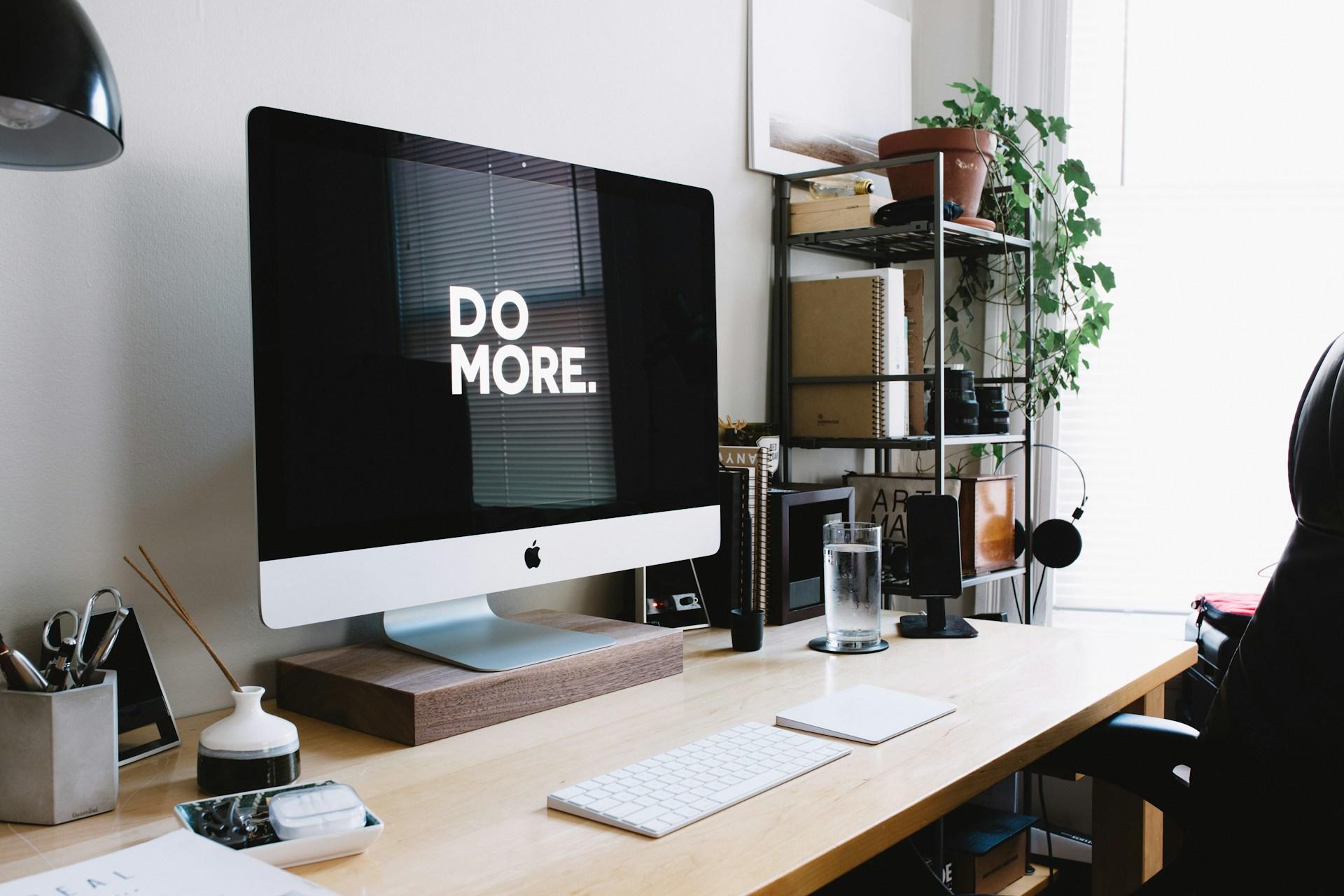 A desk with a computer and a sign that says 