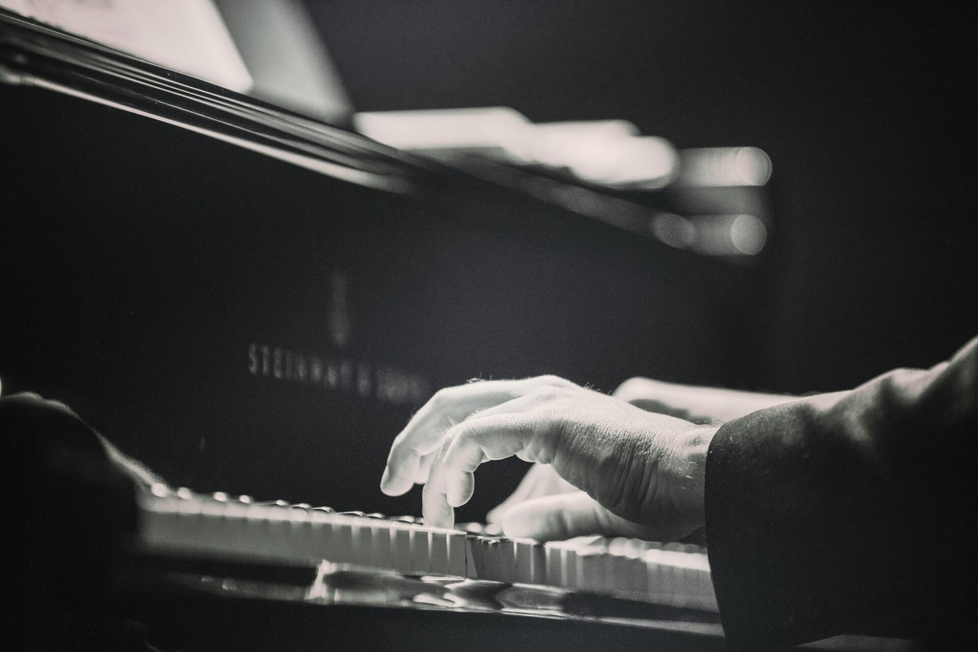 A black and white photo of a Steinway piano and pianist.