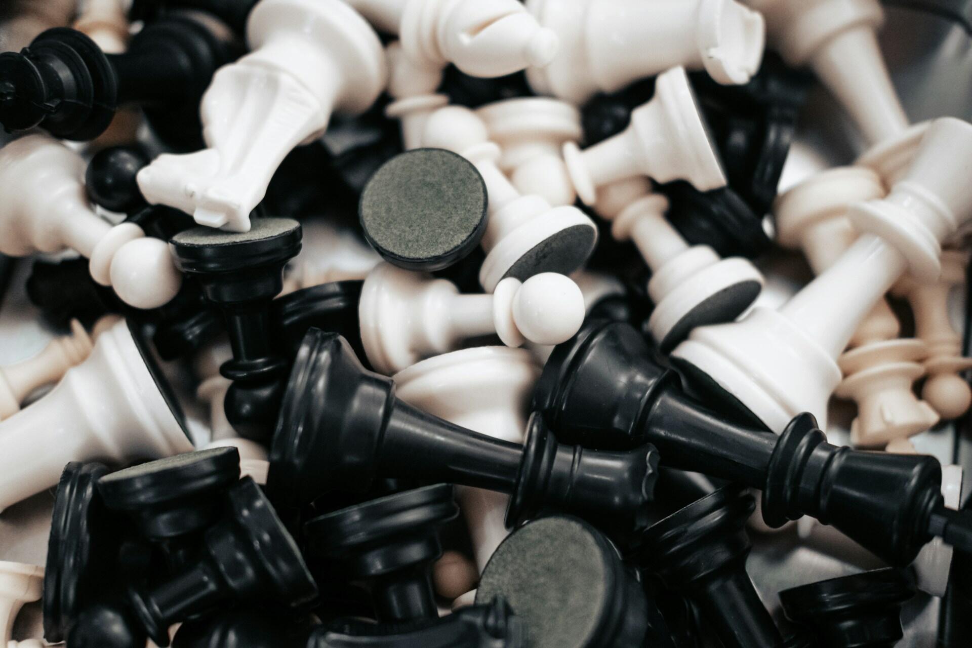 A pile of scattered black and white chess pieces.