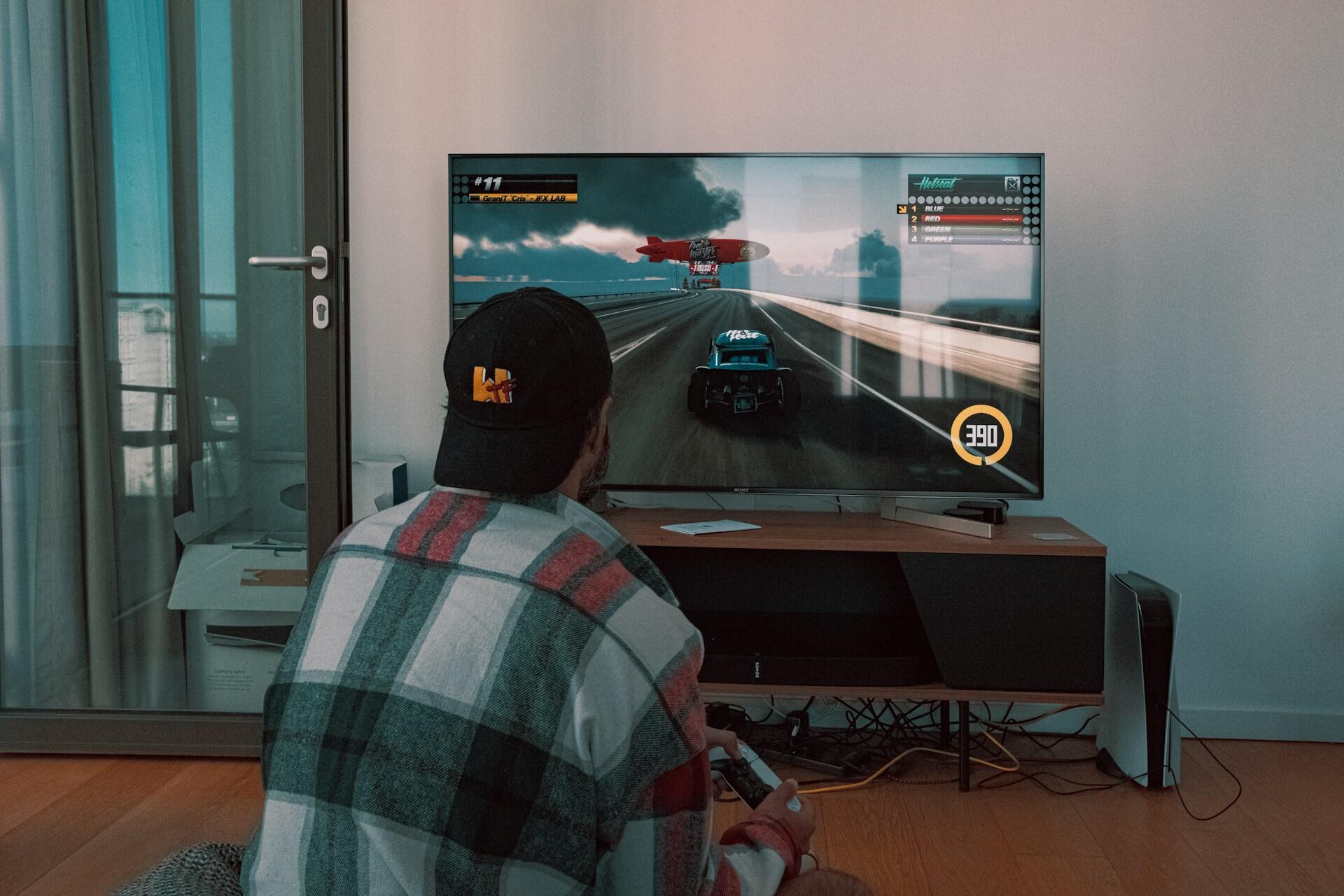 A person sitting in front of a flatscreen TV.