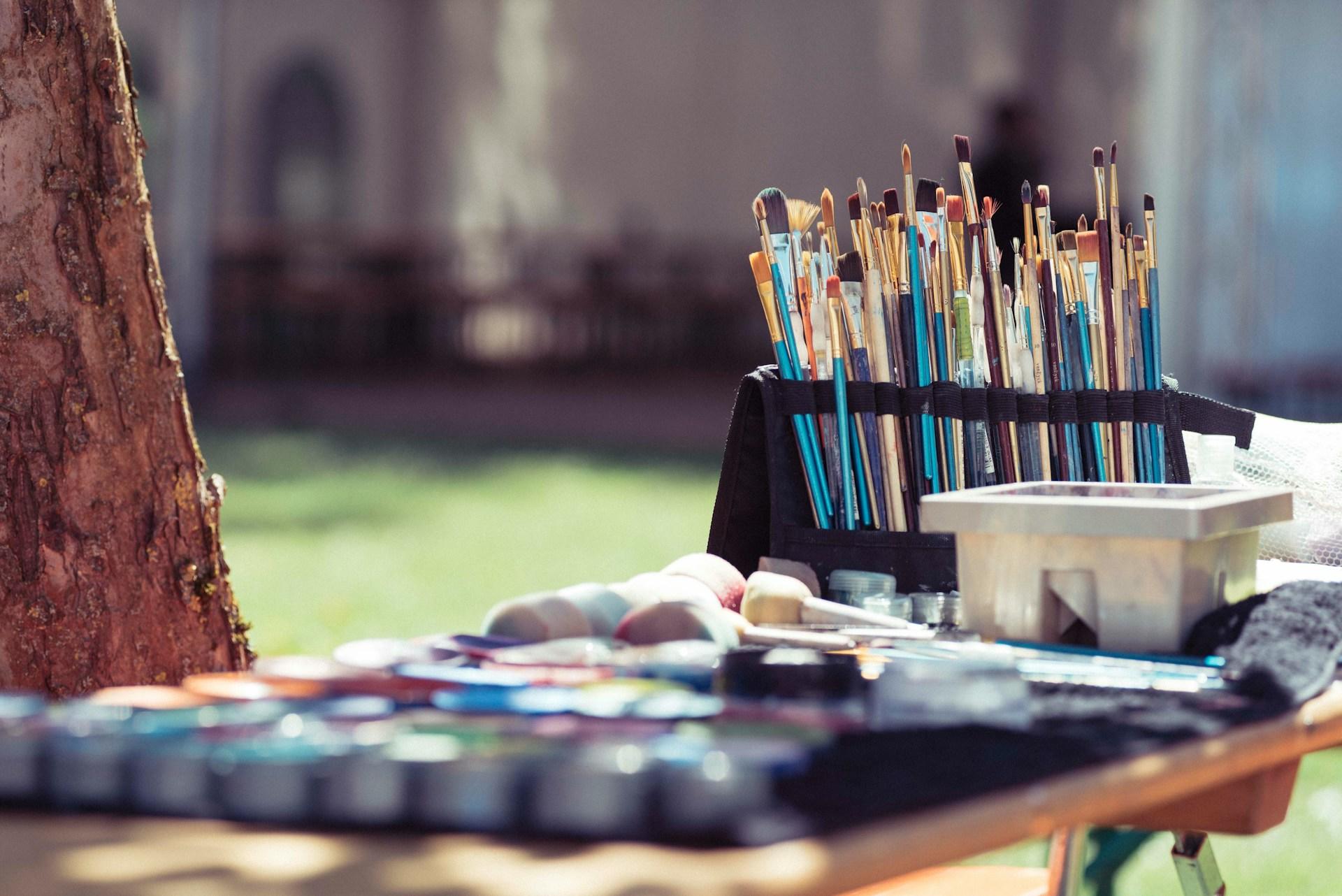 a table with paint brushes and paints