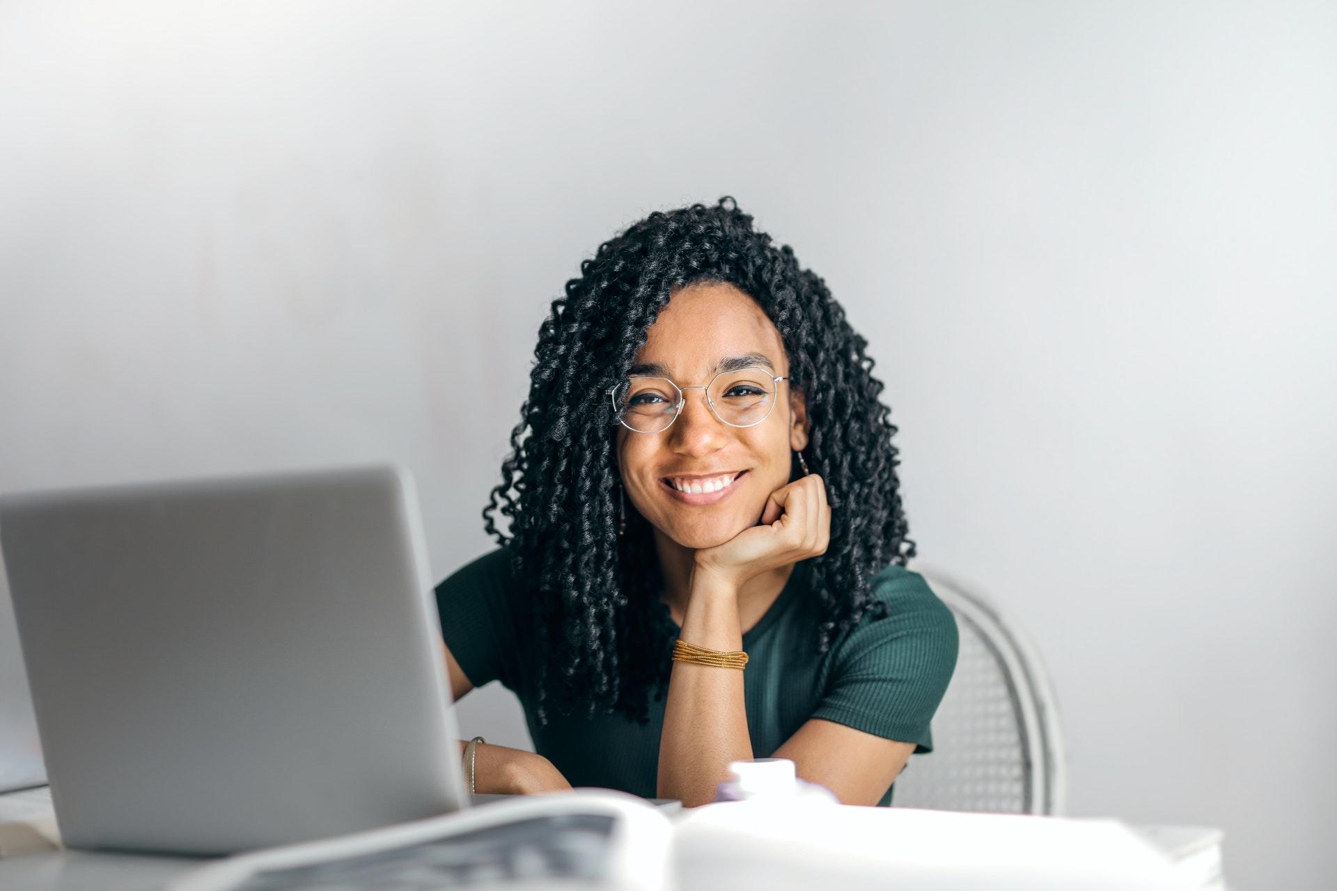 young woman in front of computer smiling