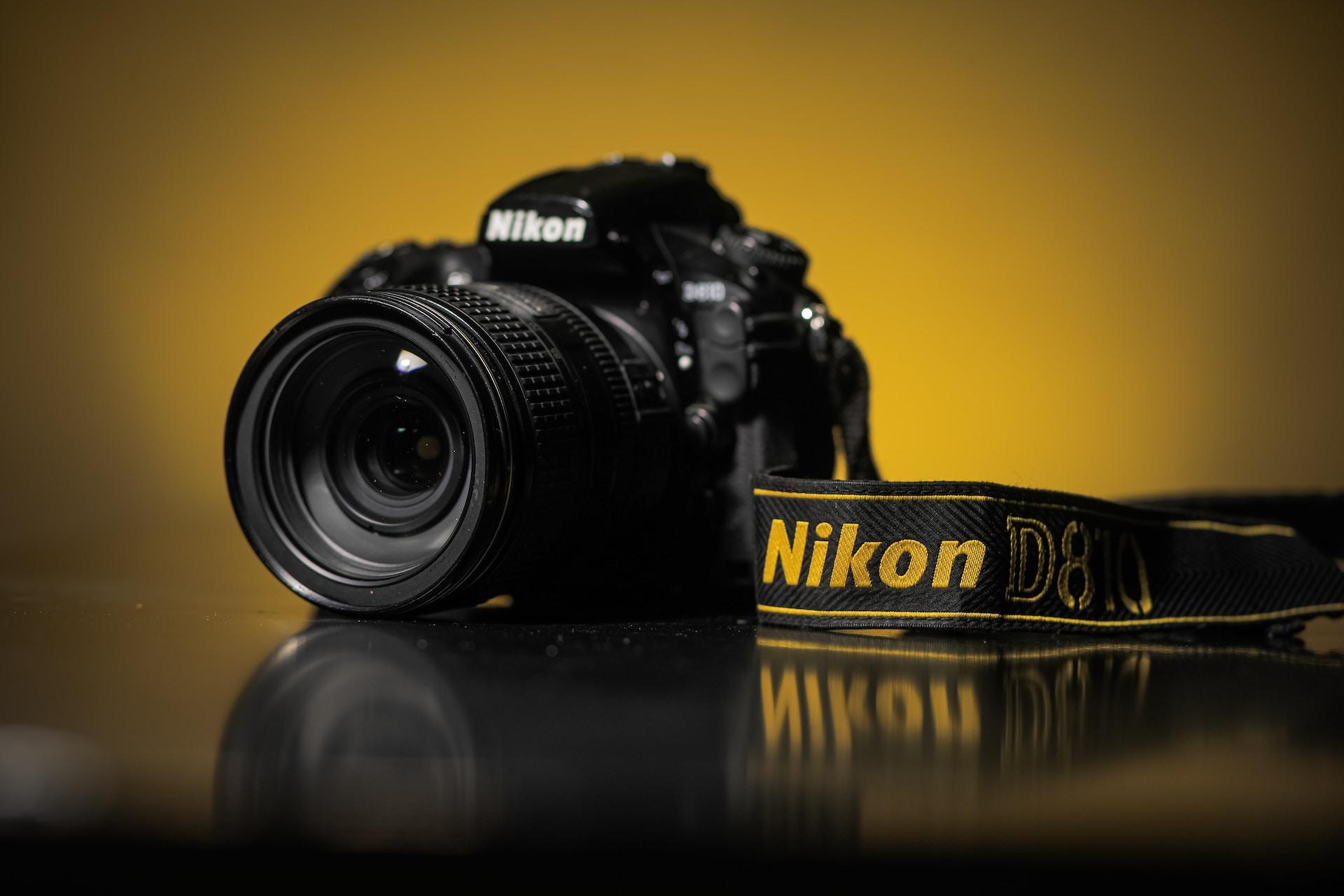 A closeup of a black Nikon D810 camera.