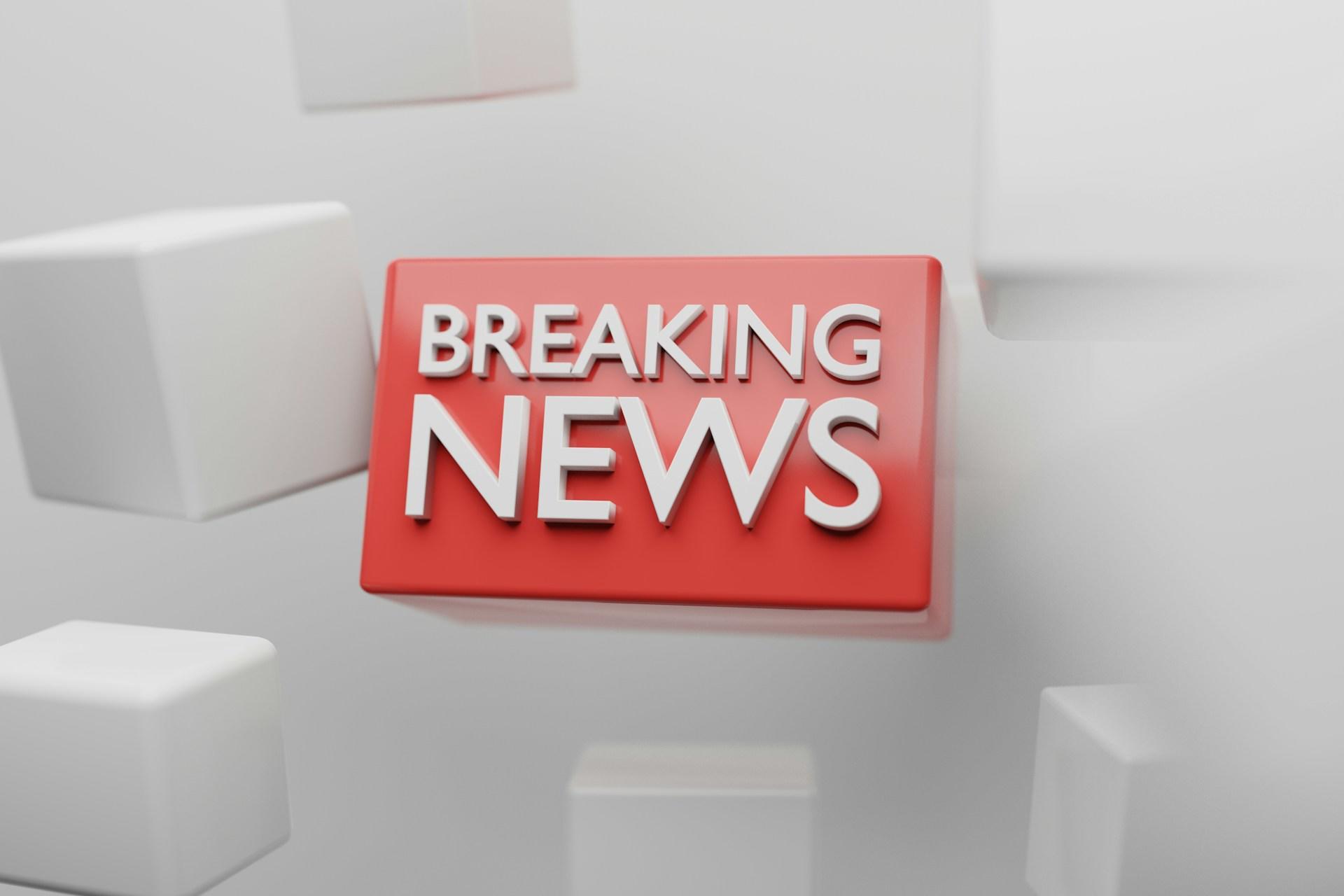 Red breaking news button with white cubes set against a grey background