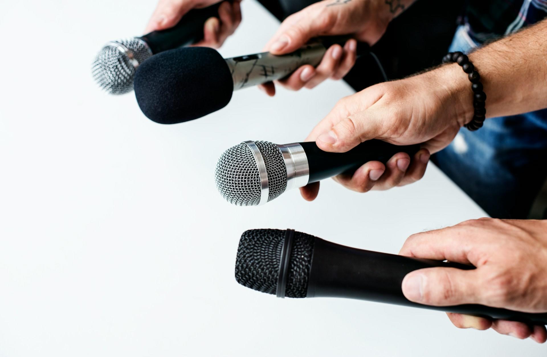 Hands holding microphones pointing at the samendirection.