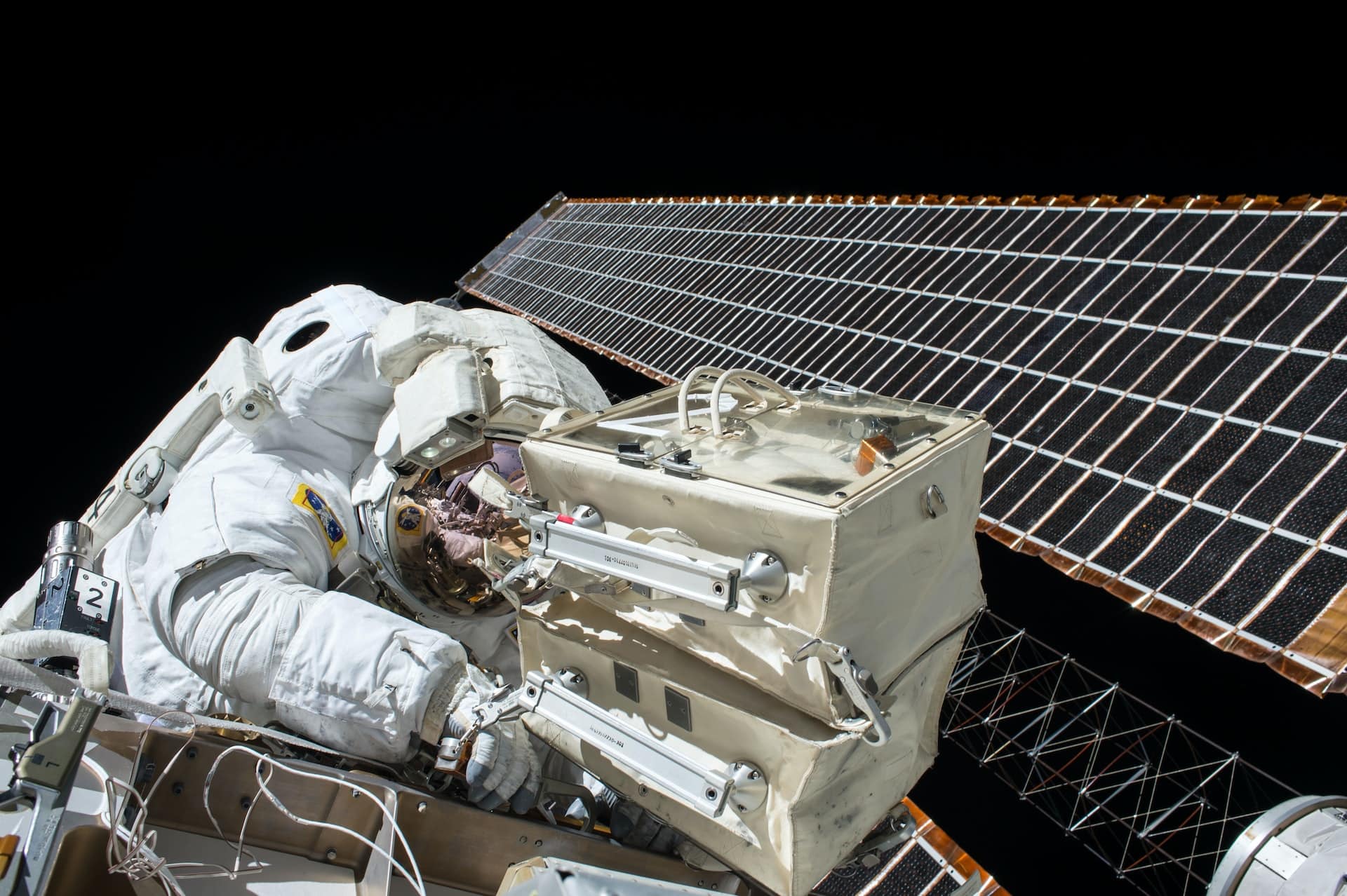 A solar array in space with a cosmonaut working on it