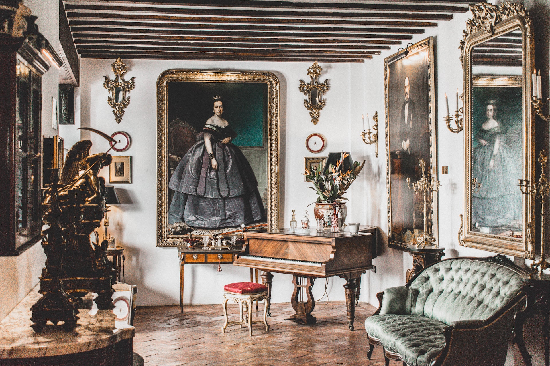 A baroque music room with a large painting of a woman hanging over the piano and several accent pieces in the foreground