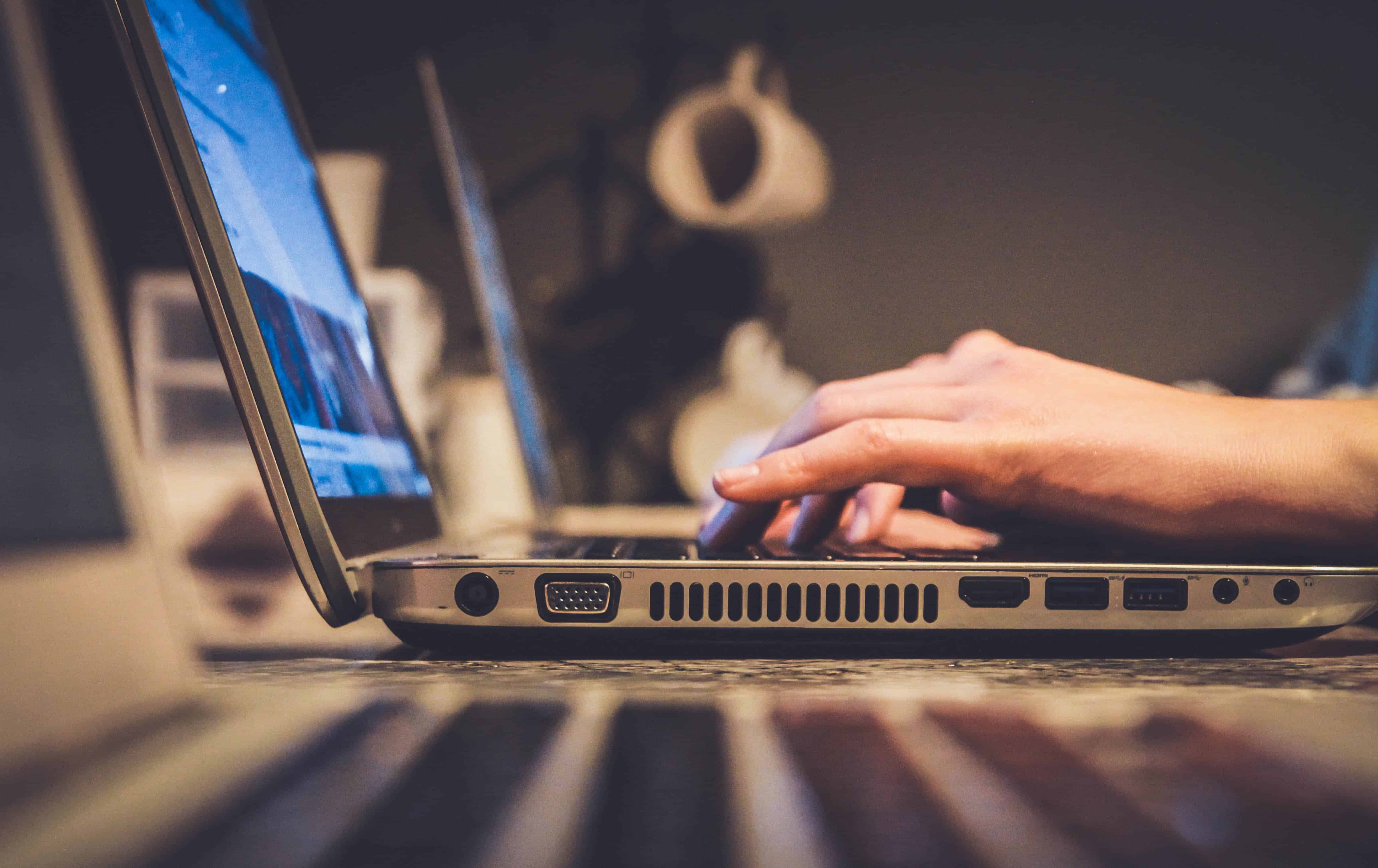 Hands typing on a laptop computer