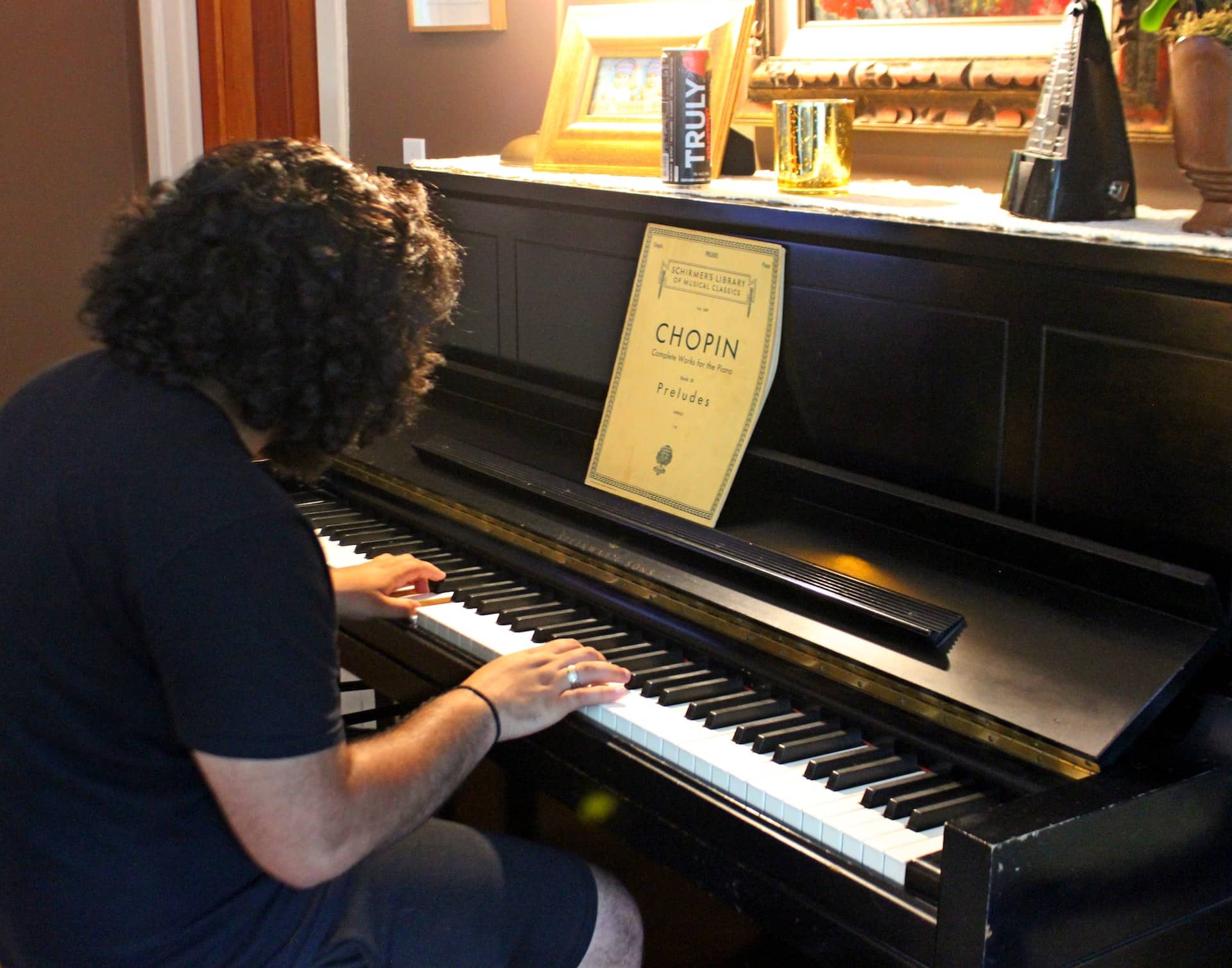A woman in a short-sleeved black dress playing Chopin on the piano