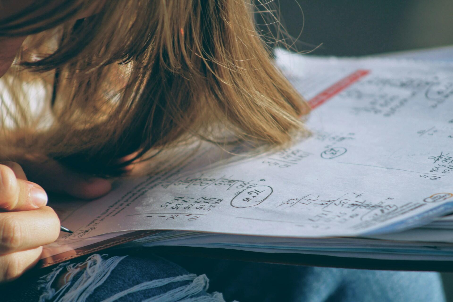 Student working through maths problems in a workbook