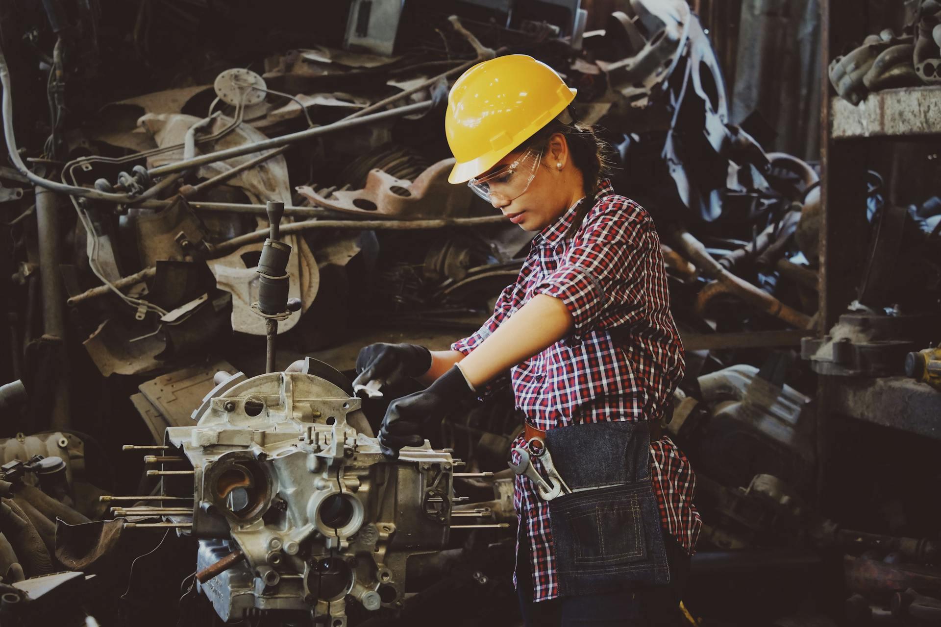 a factory worker making a machine part