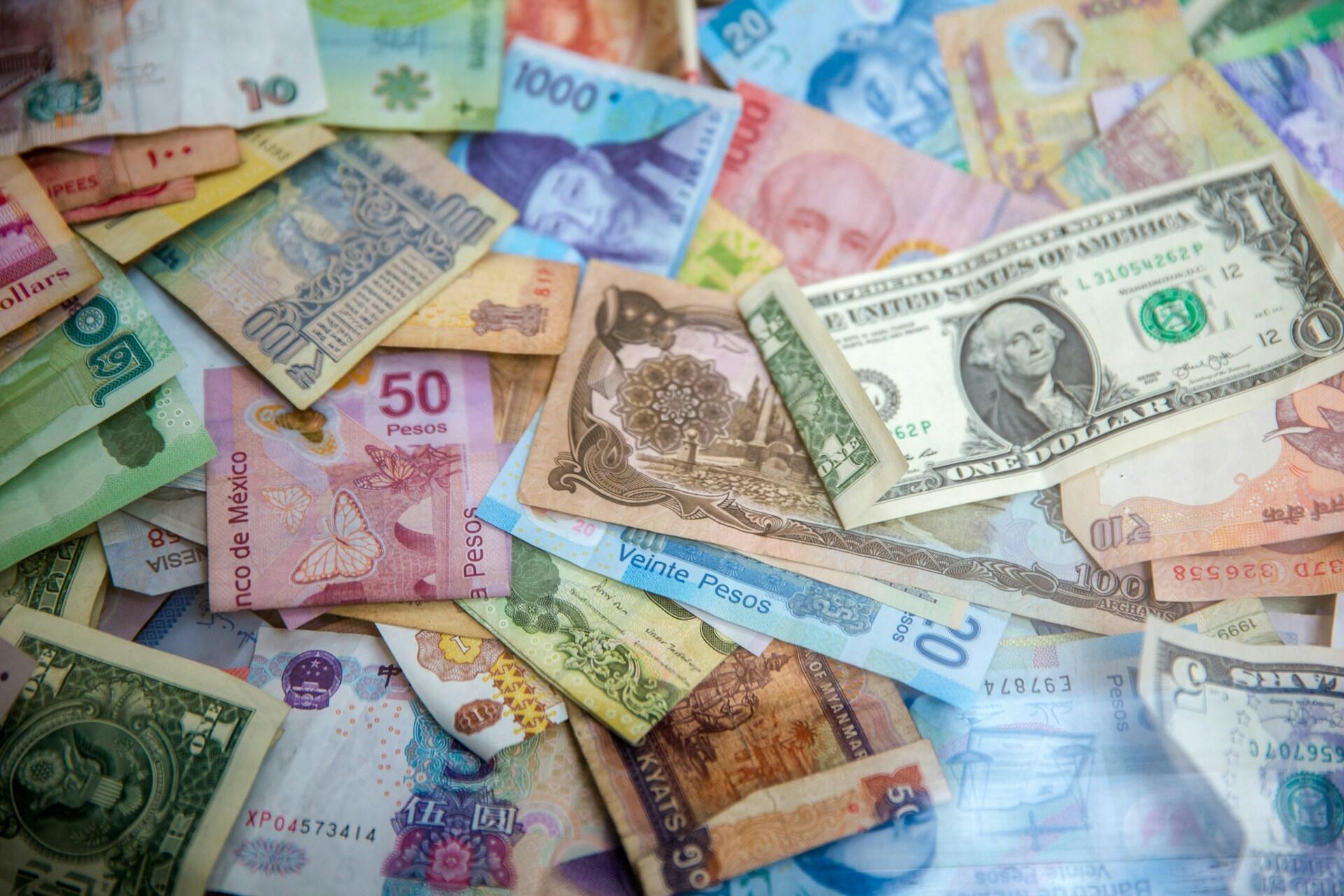 a pile of banknotes from many different countries