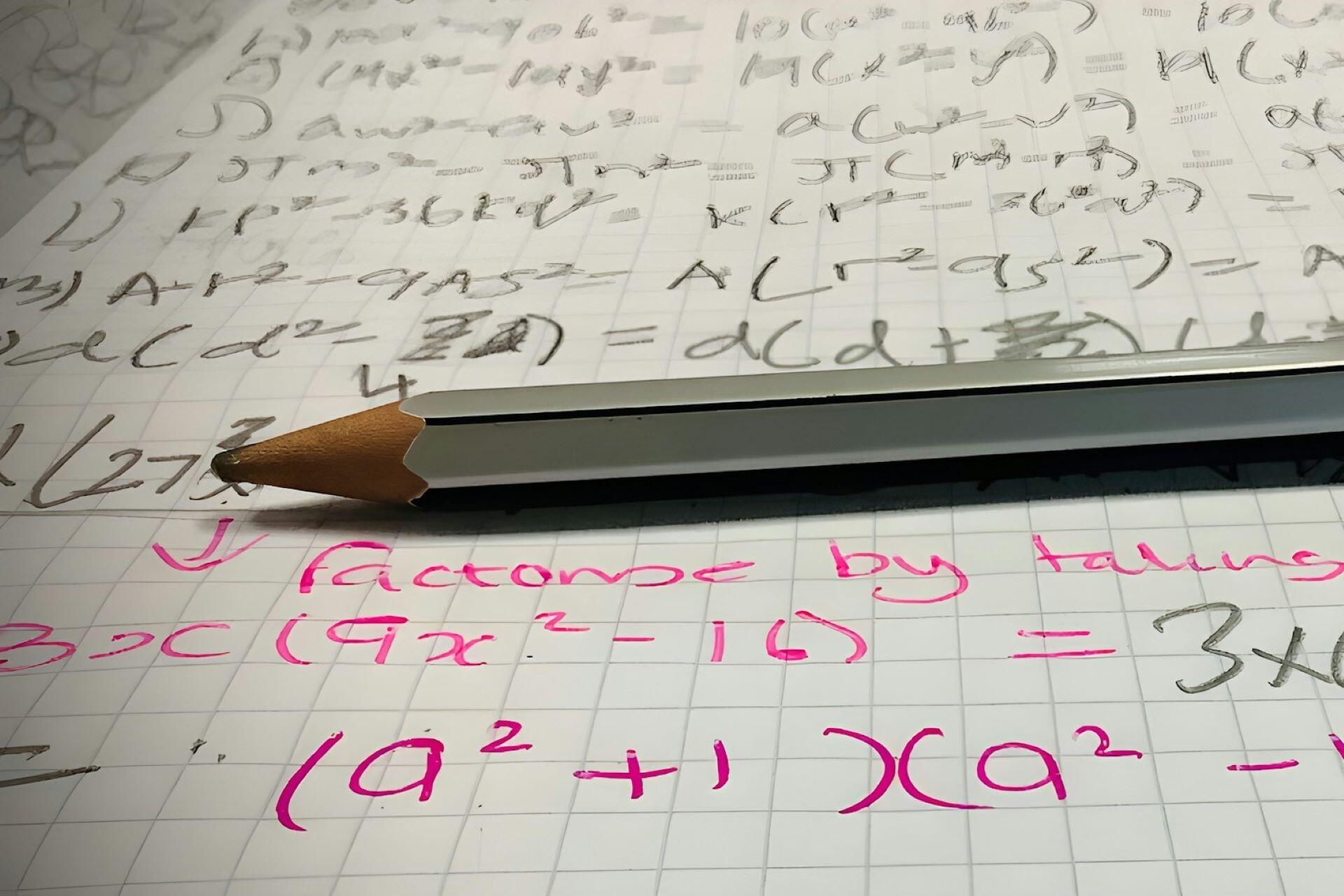 Pencil resting on handwritten mathematical equations and calculations