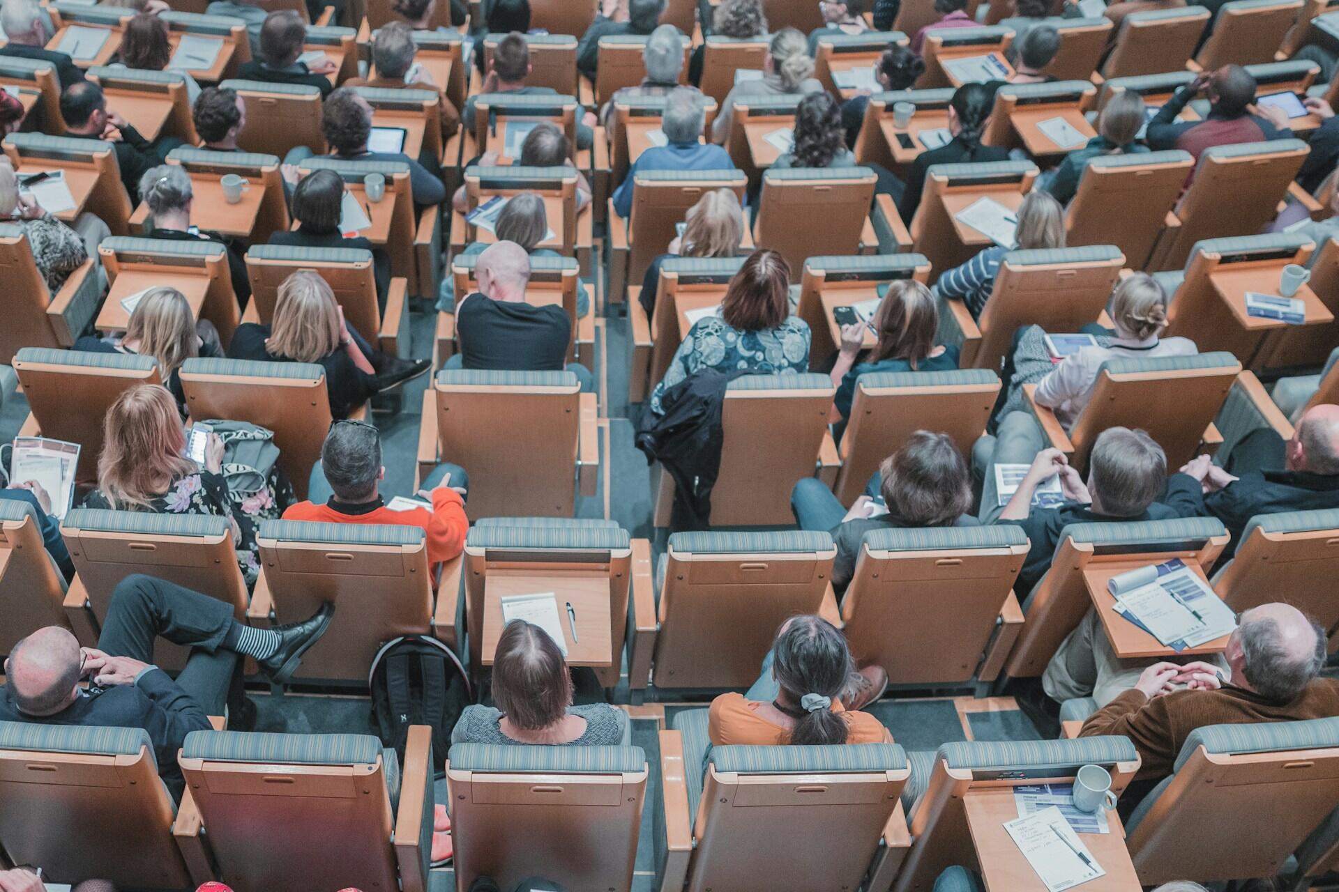 People seated in rows in a university lecture theatre