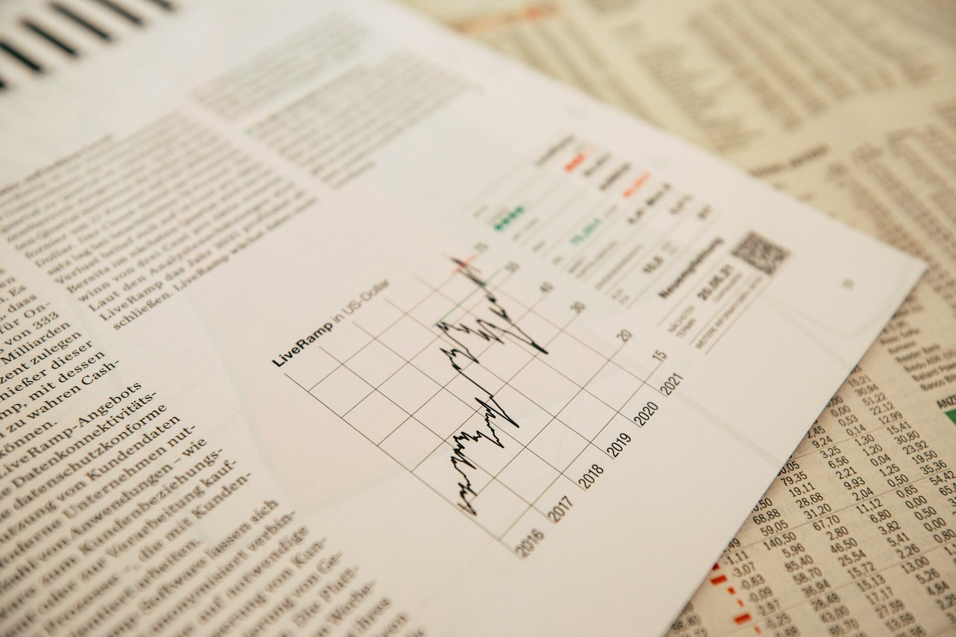 Printed line graph on newspaper pages with numerical data