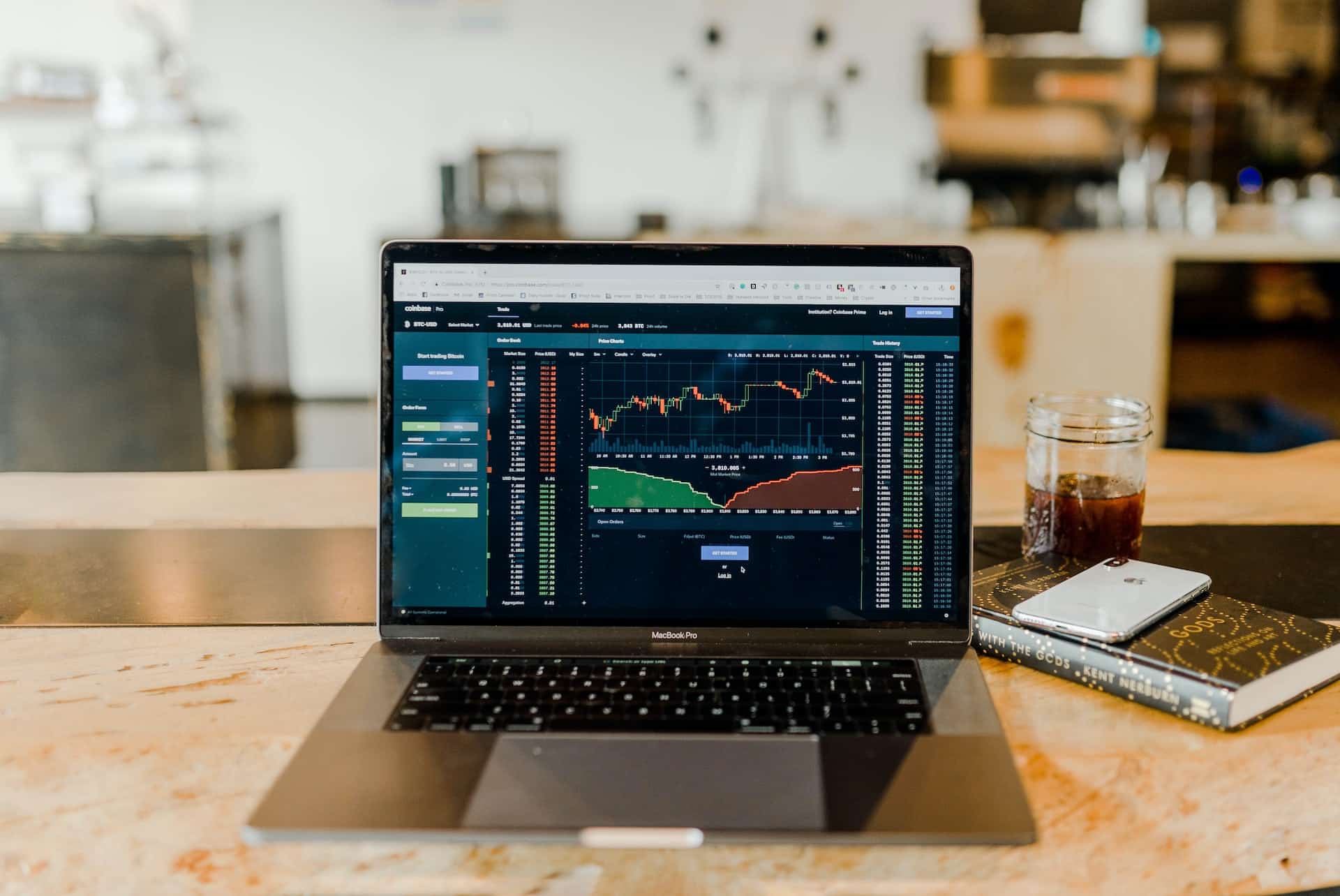 An open laptop computer displaying a stock performance page resting on a wooden table.