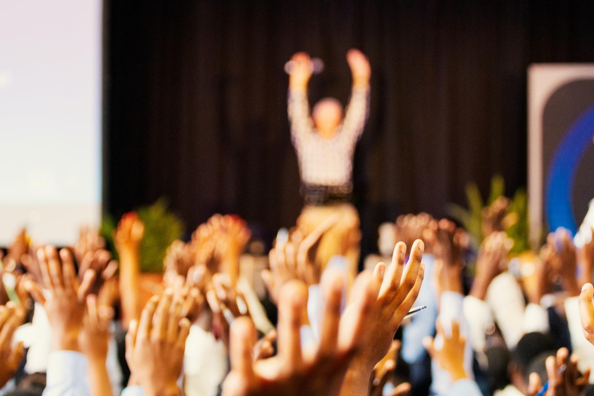 Students raising hands in school hall