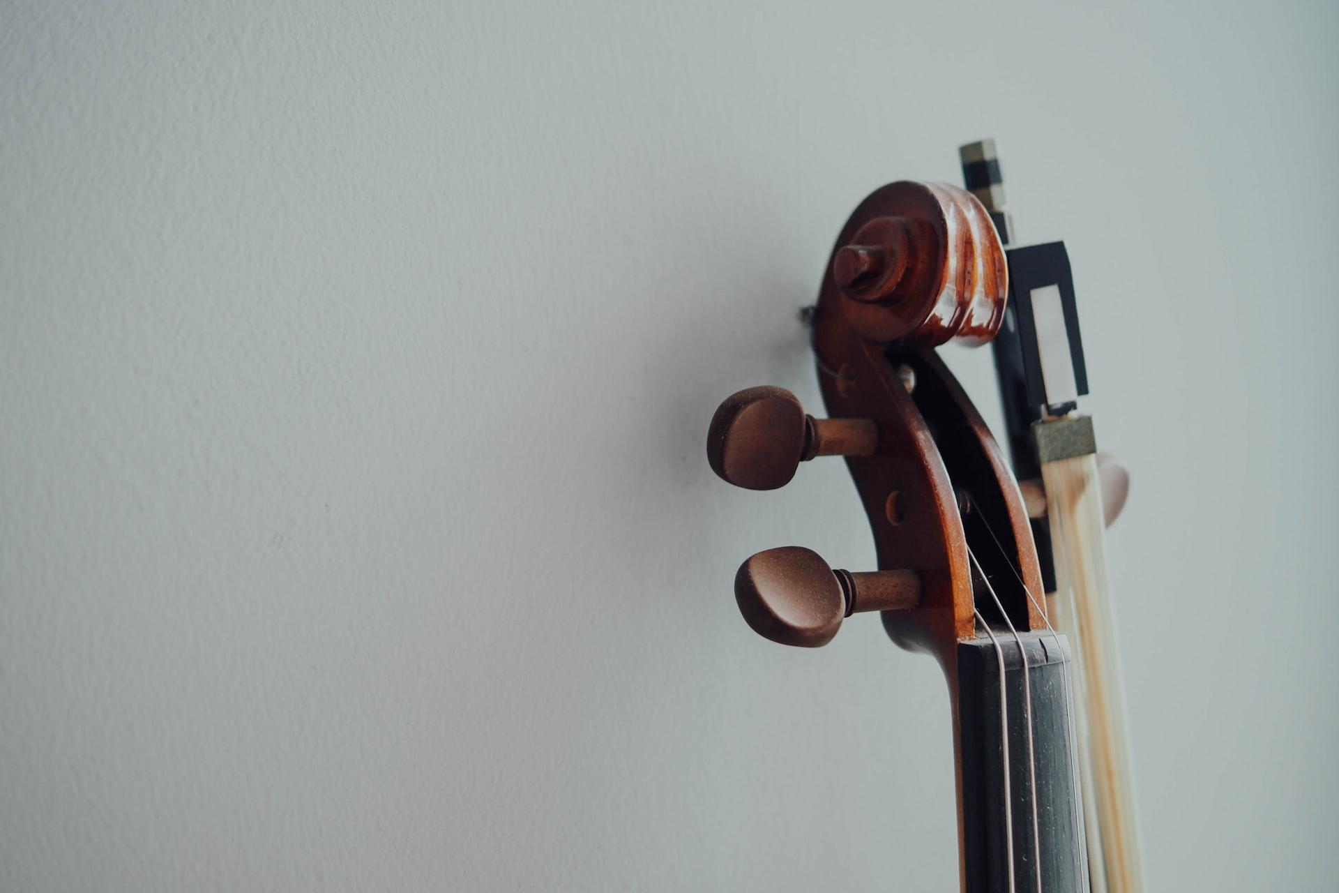 A closeup of a violin head and bow