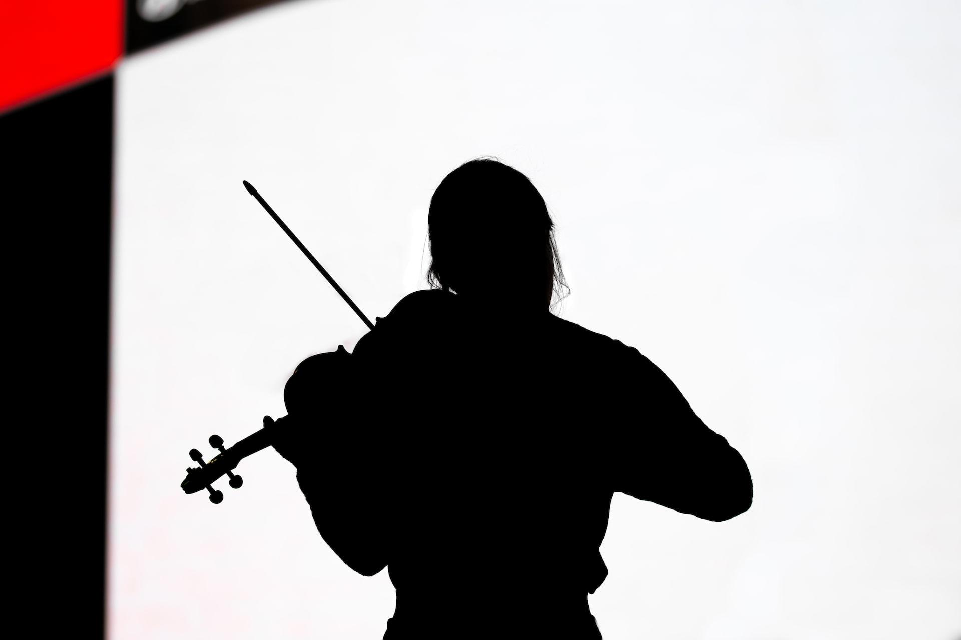 A silhouette of a violinist on stage