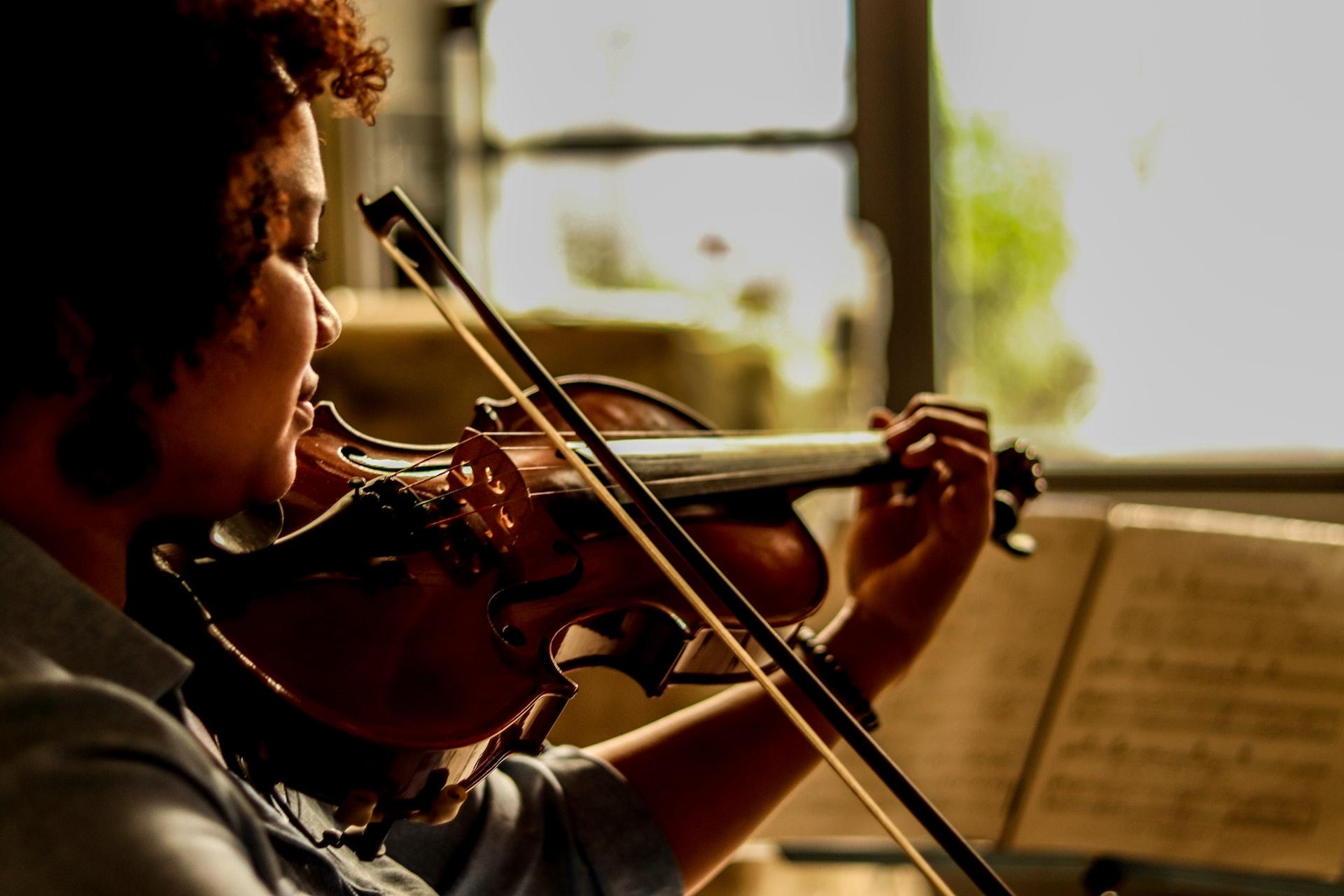 A violinist playing in front of some sheet music