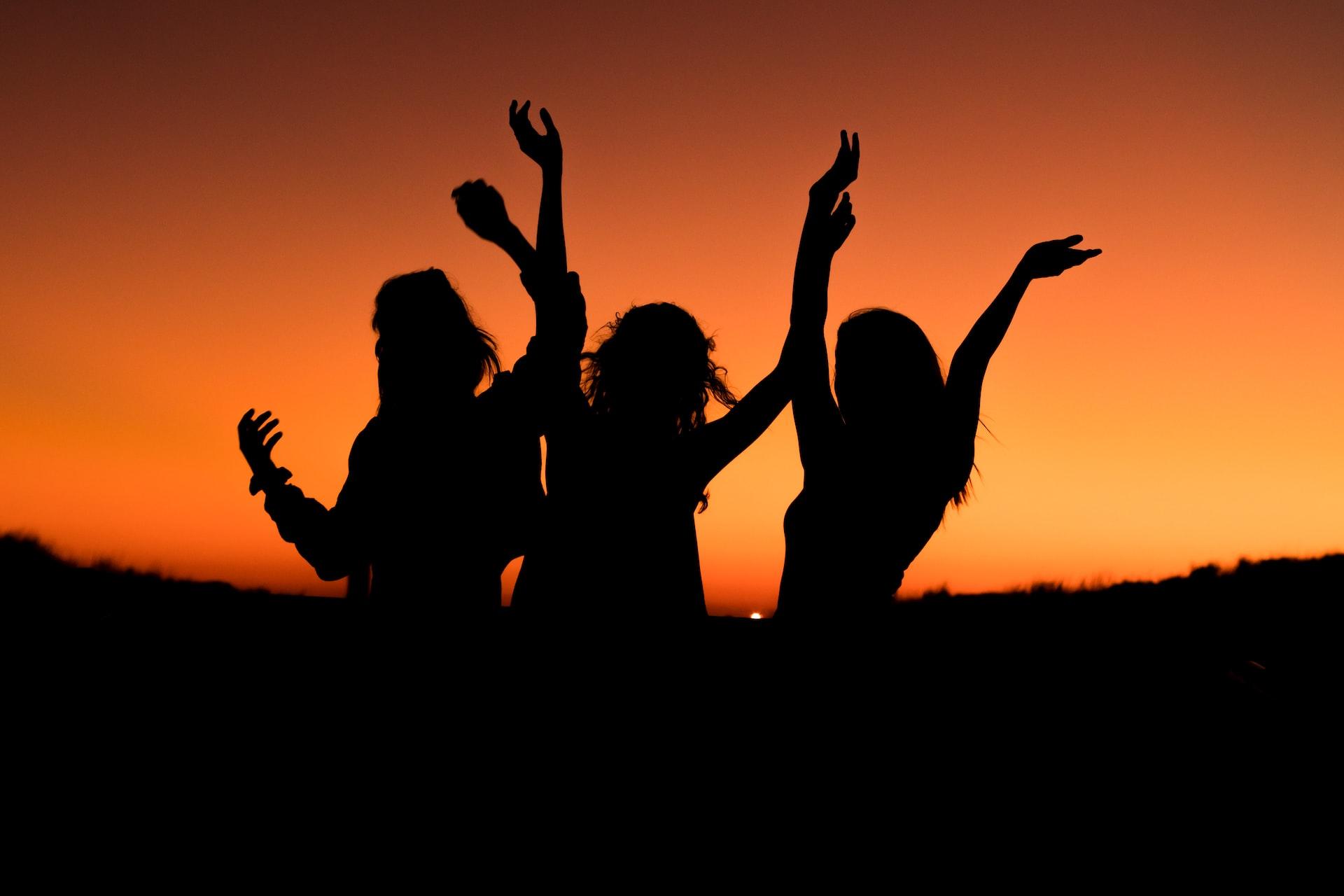 Girls dancing silhouetted against the sunset