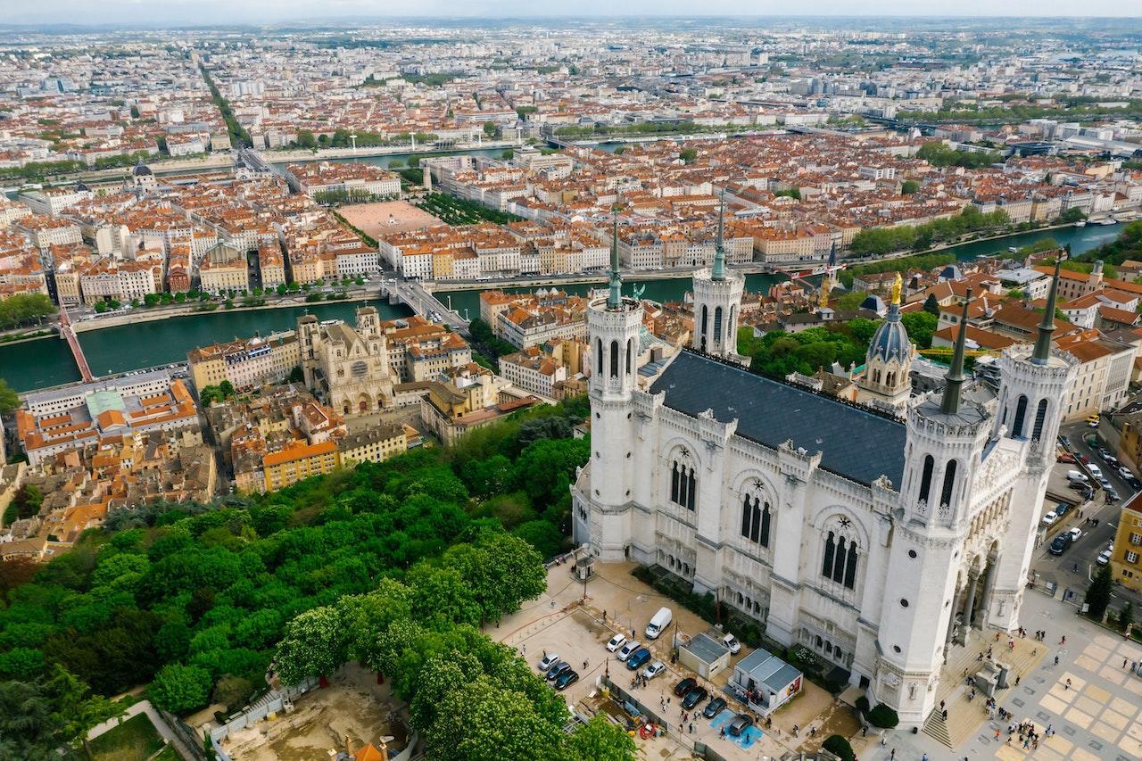 Aerial photo of a cathedral and city buildings in Lyon, France.