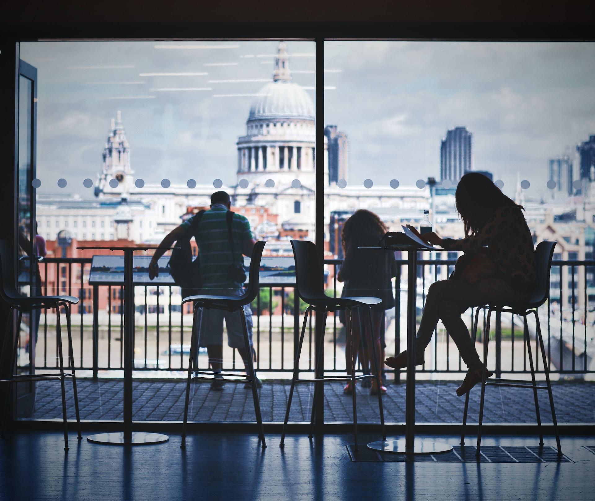 Students are sitting at tables and studying with a monument in the background.