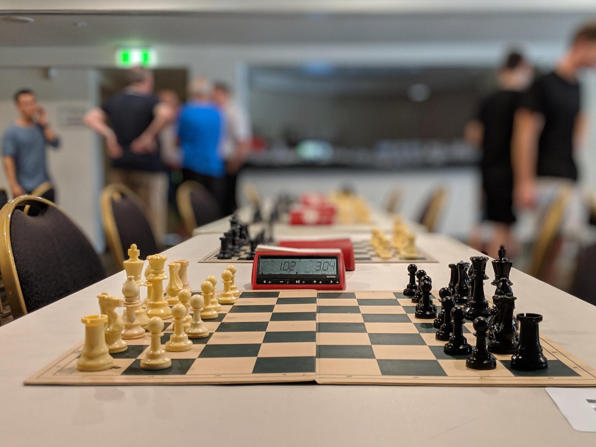 A chess board in the starting position with a chess clock.
