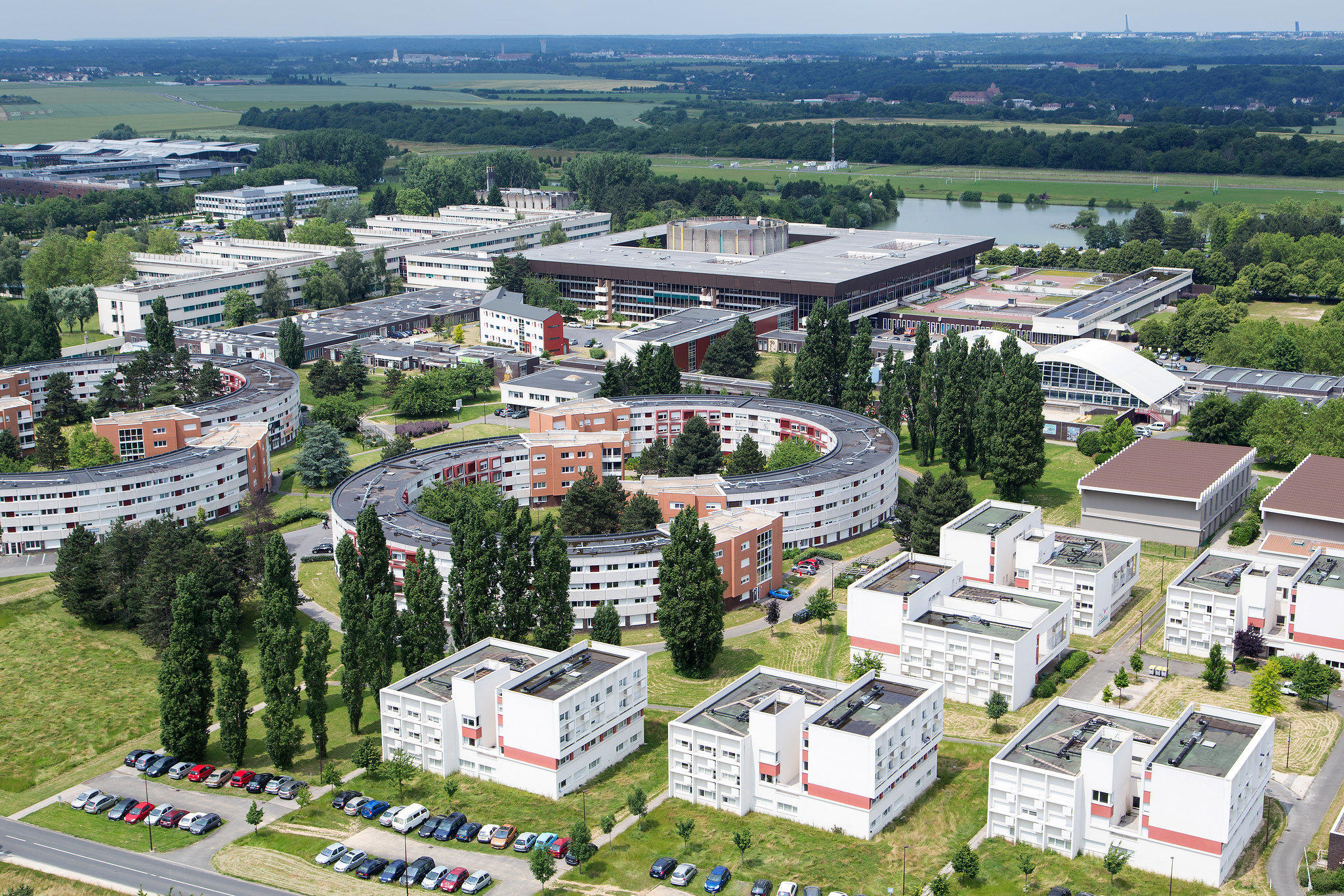 An aerial view of ecole polytechnique campus with interesting architecture, grass, and trees