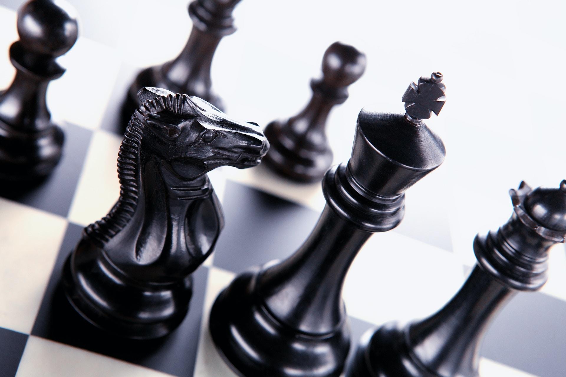 A closeup of a chess knight, queen, and king.