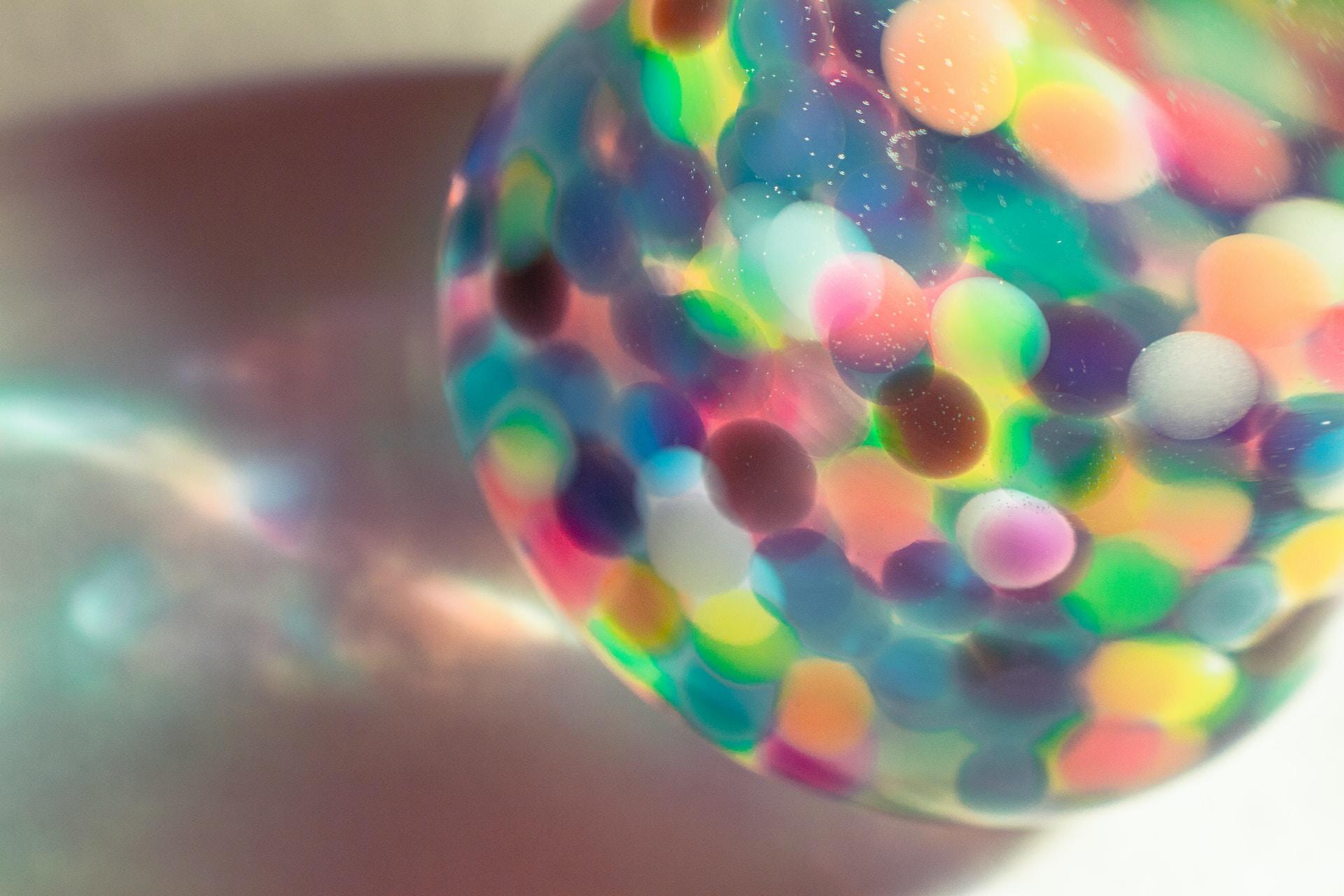 A closeup of a conical flask with a multicoloured liquid inside.
