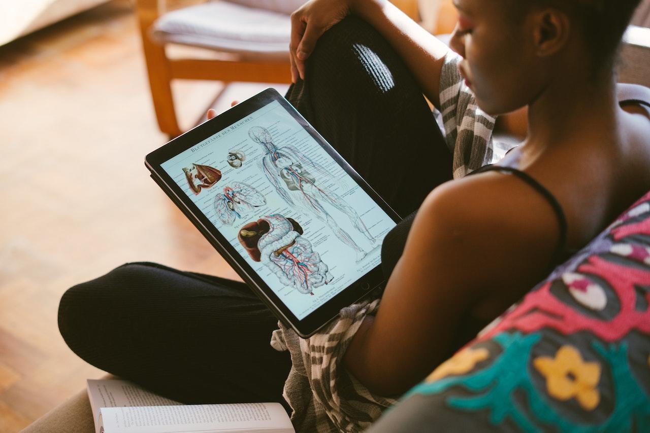 A student looks at a picture of human anatomy on a tablet screen.