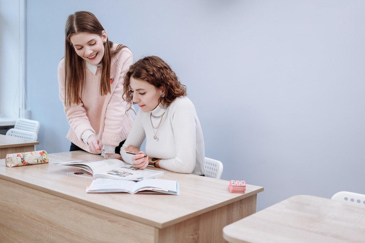 A tutor helps a tutee by looking through textbooks