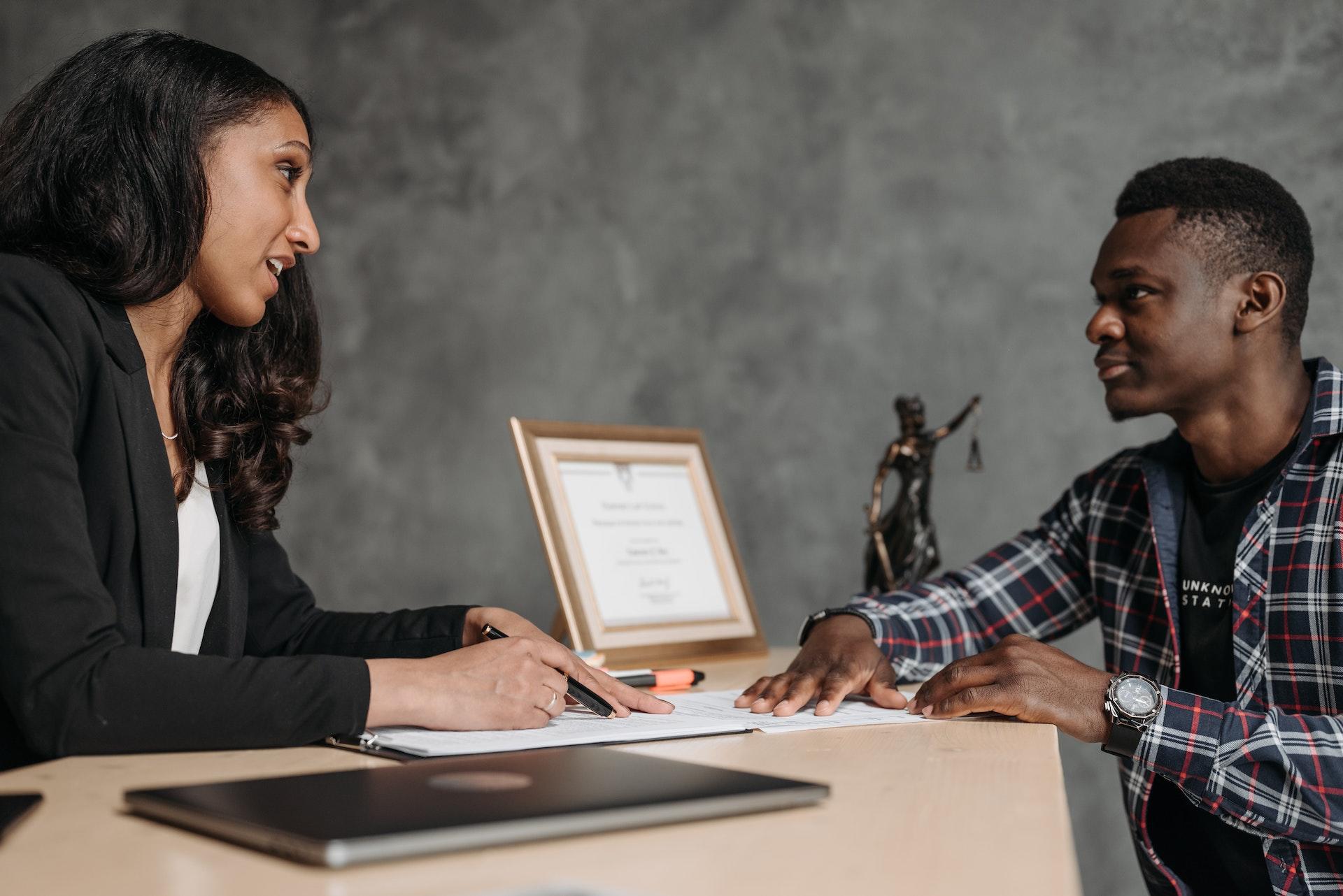 A lawyer and their client going over a contract.