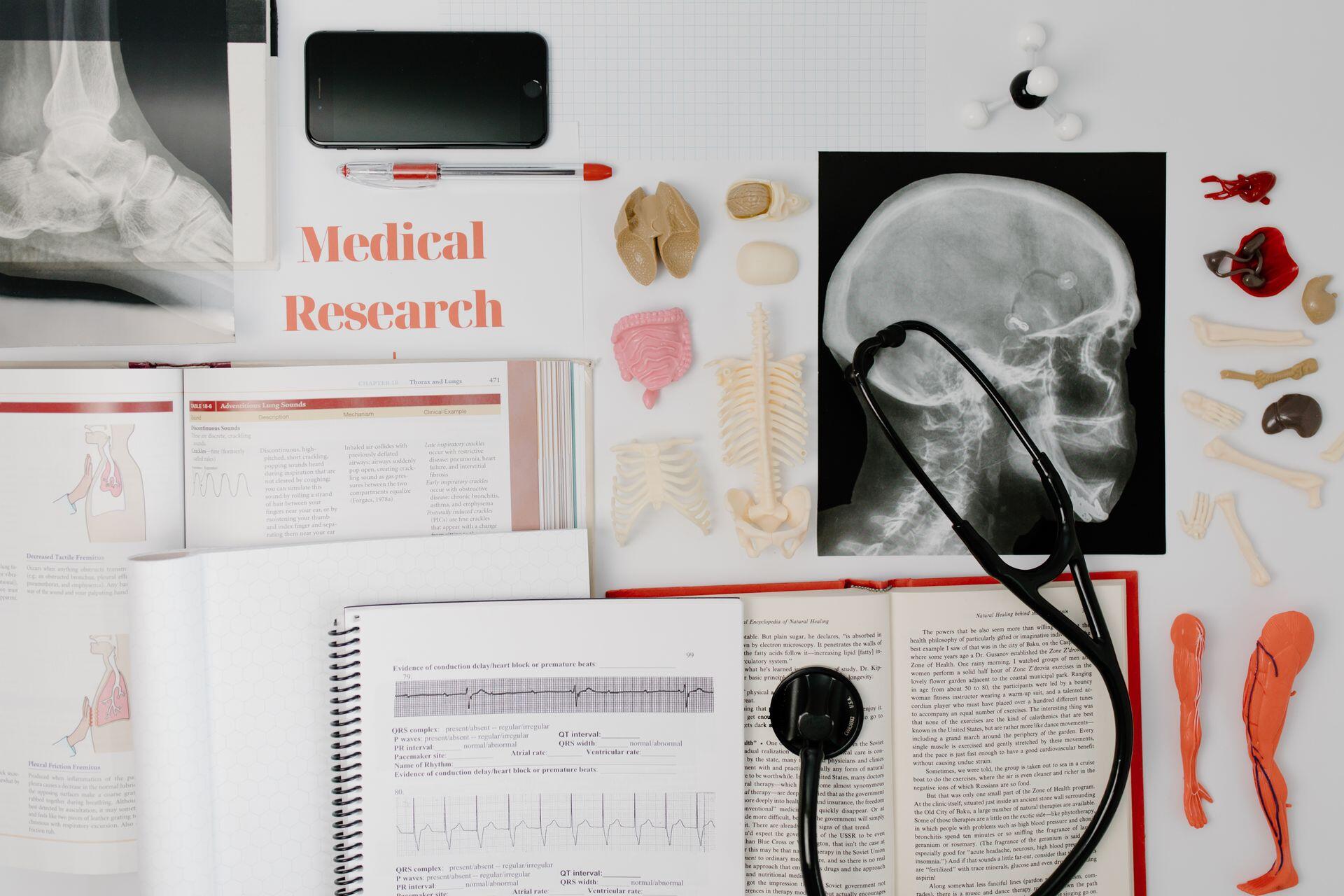 top down view of medical research papers, scans of the skull, and other materials