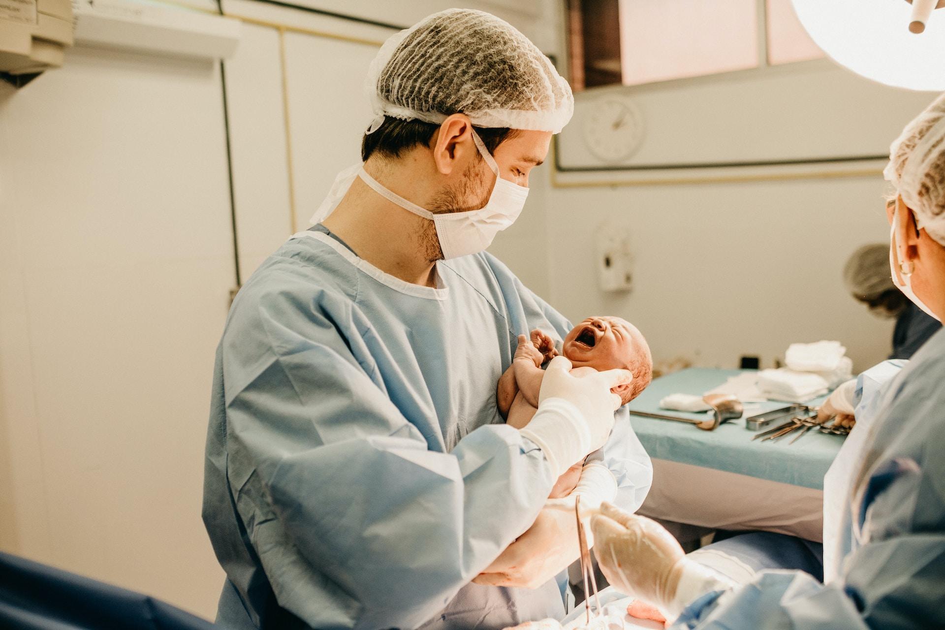 A parent holding a newborn baby in a hospital.