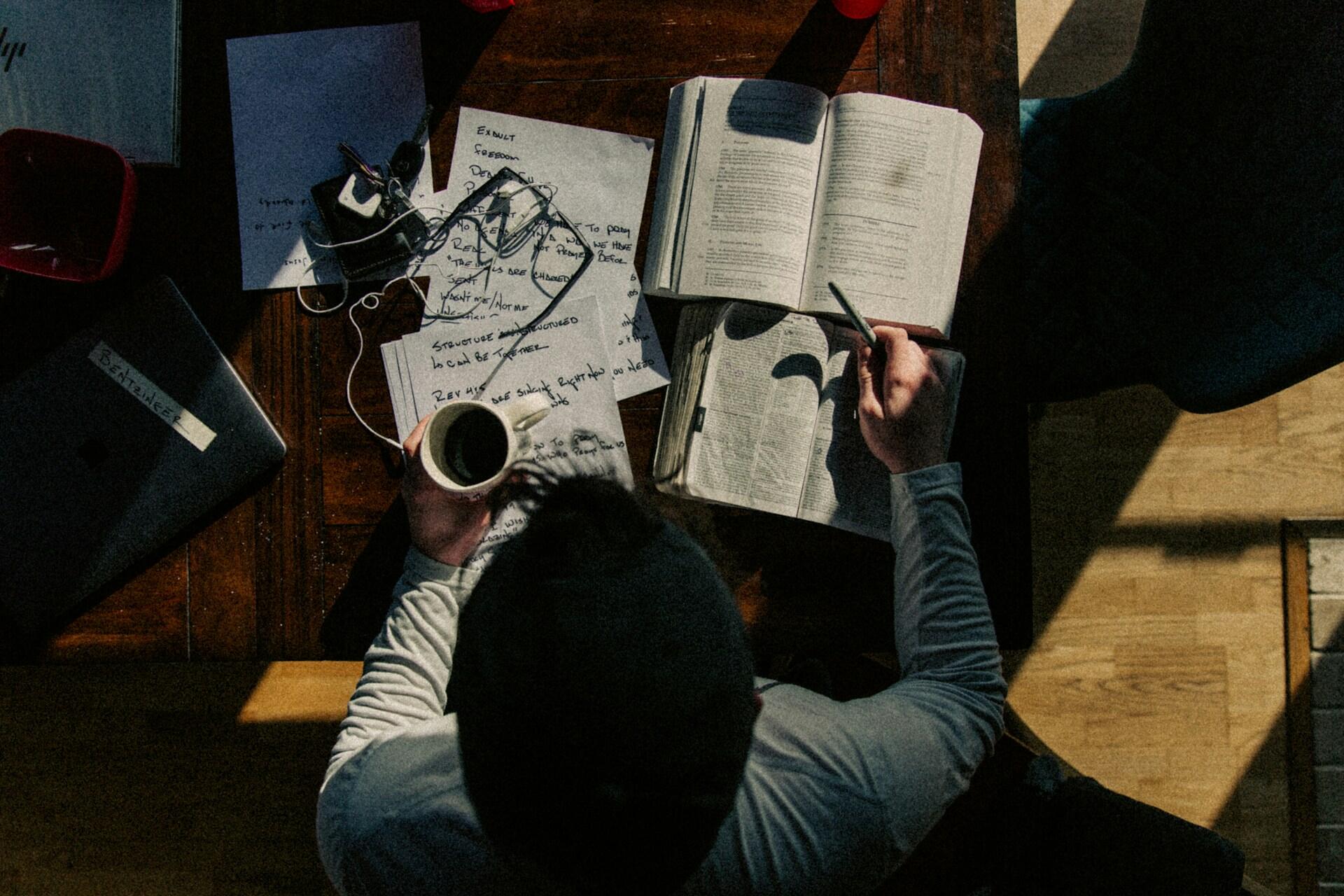 top-down view of a student with textbooks and handwritten notes on a desk
