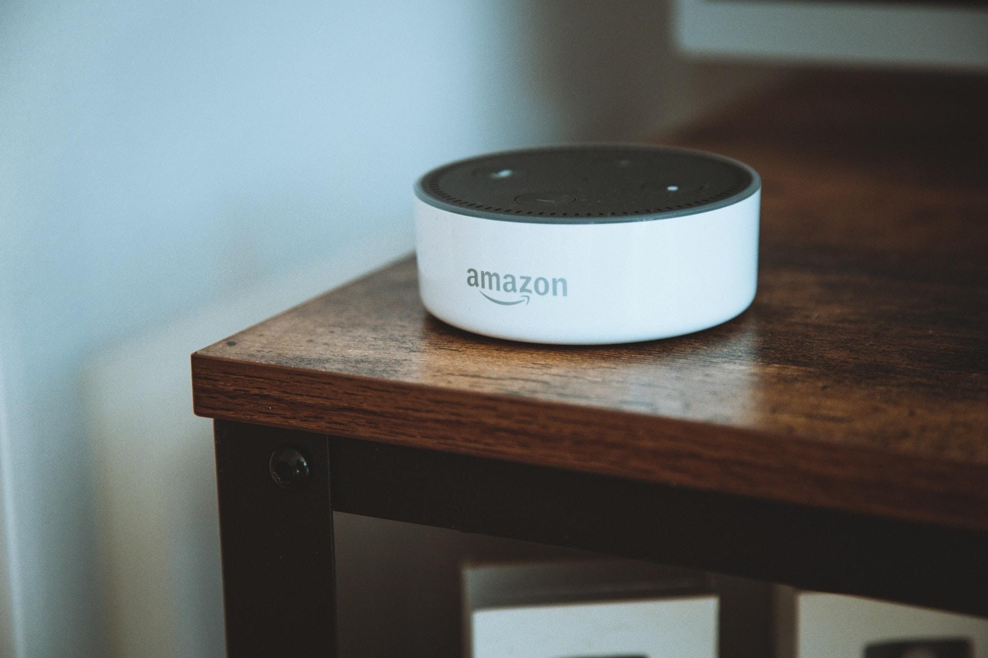 An Amazon smart speaker on a side table.