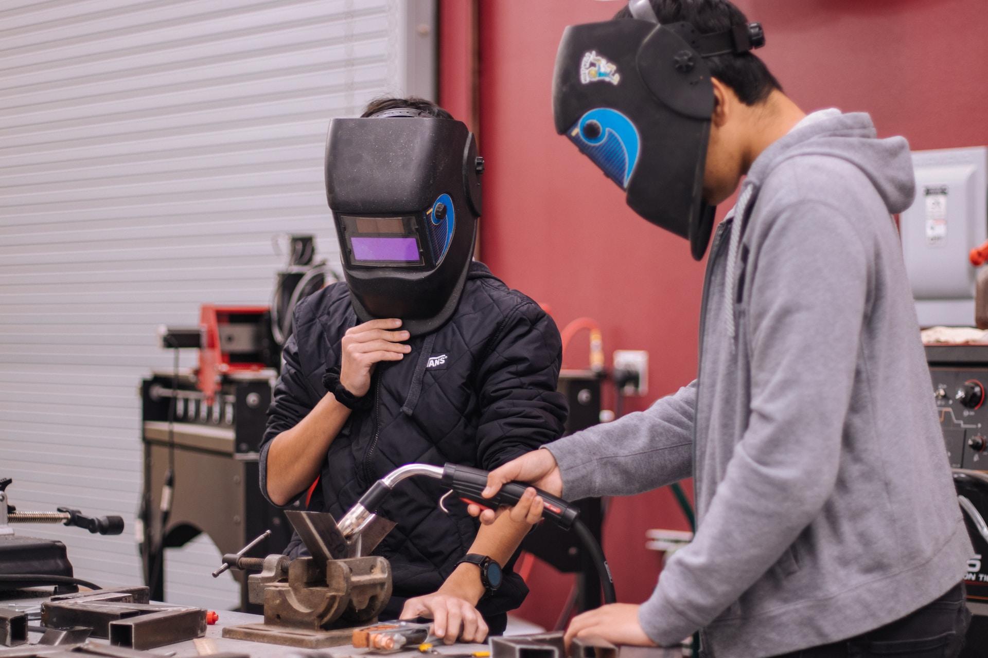 Engineering students wearing welding masks.