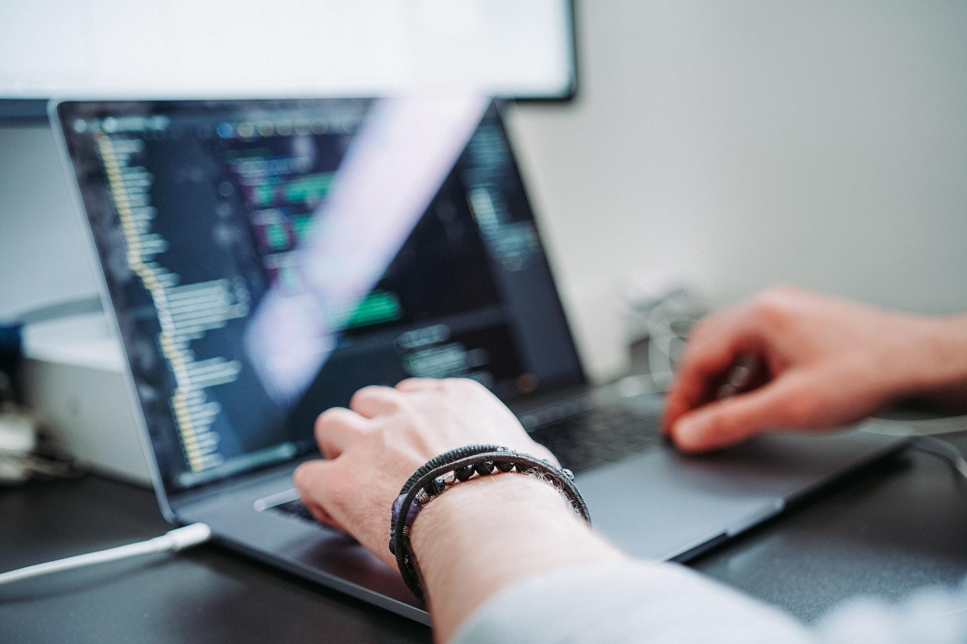 Somebody working with code on a laptop computer.