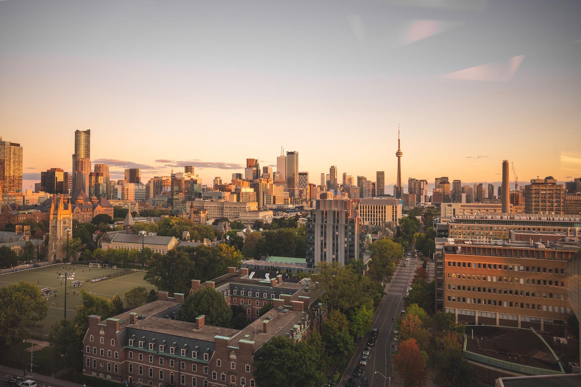 A panoramic view of the Toronto landscape seen at sunset from above, featuring the University of Toronto.