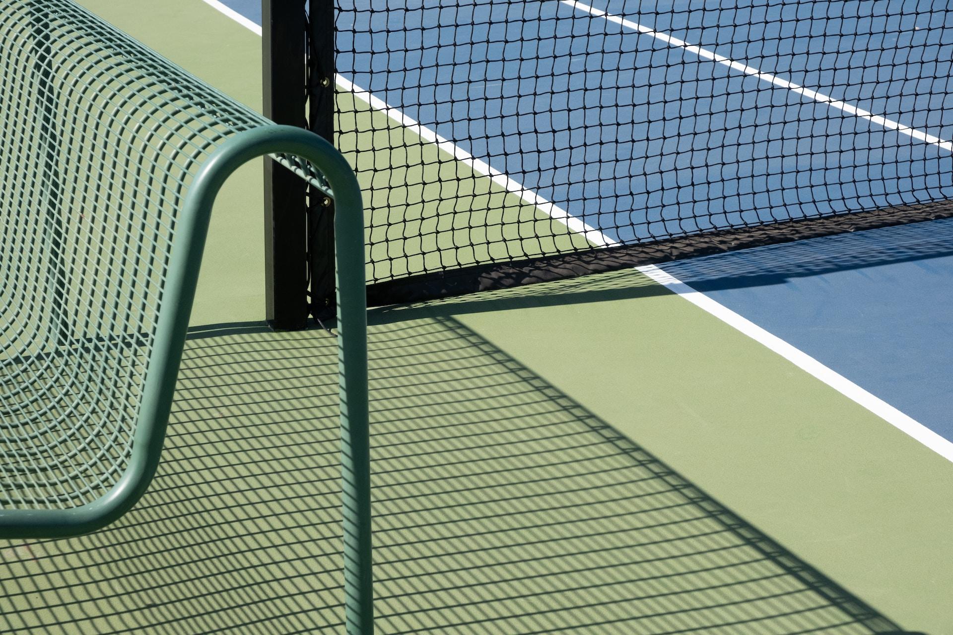 A tennis net on a hard court.
