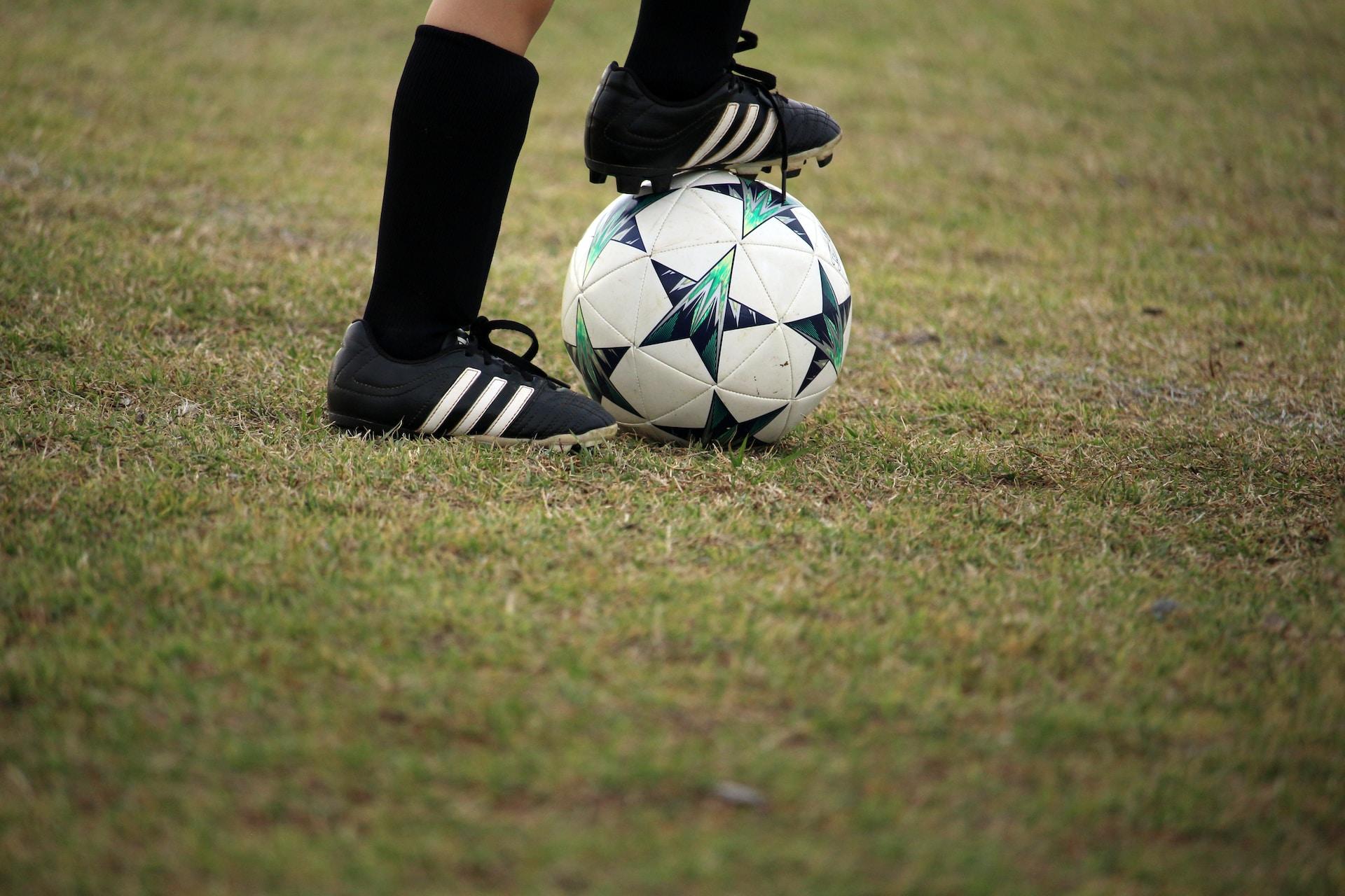 A soccer player with their foot on the ball.