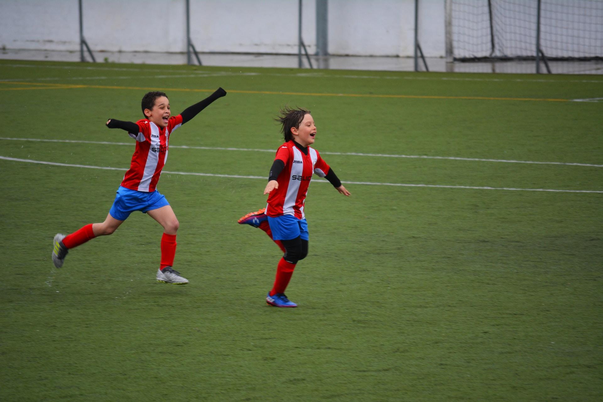 Junior soccer players celebrating a goal.