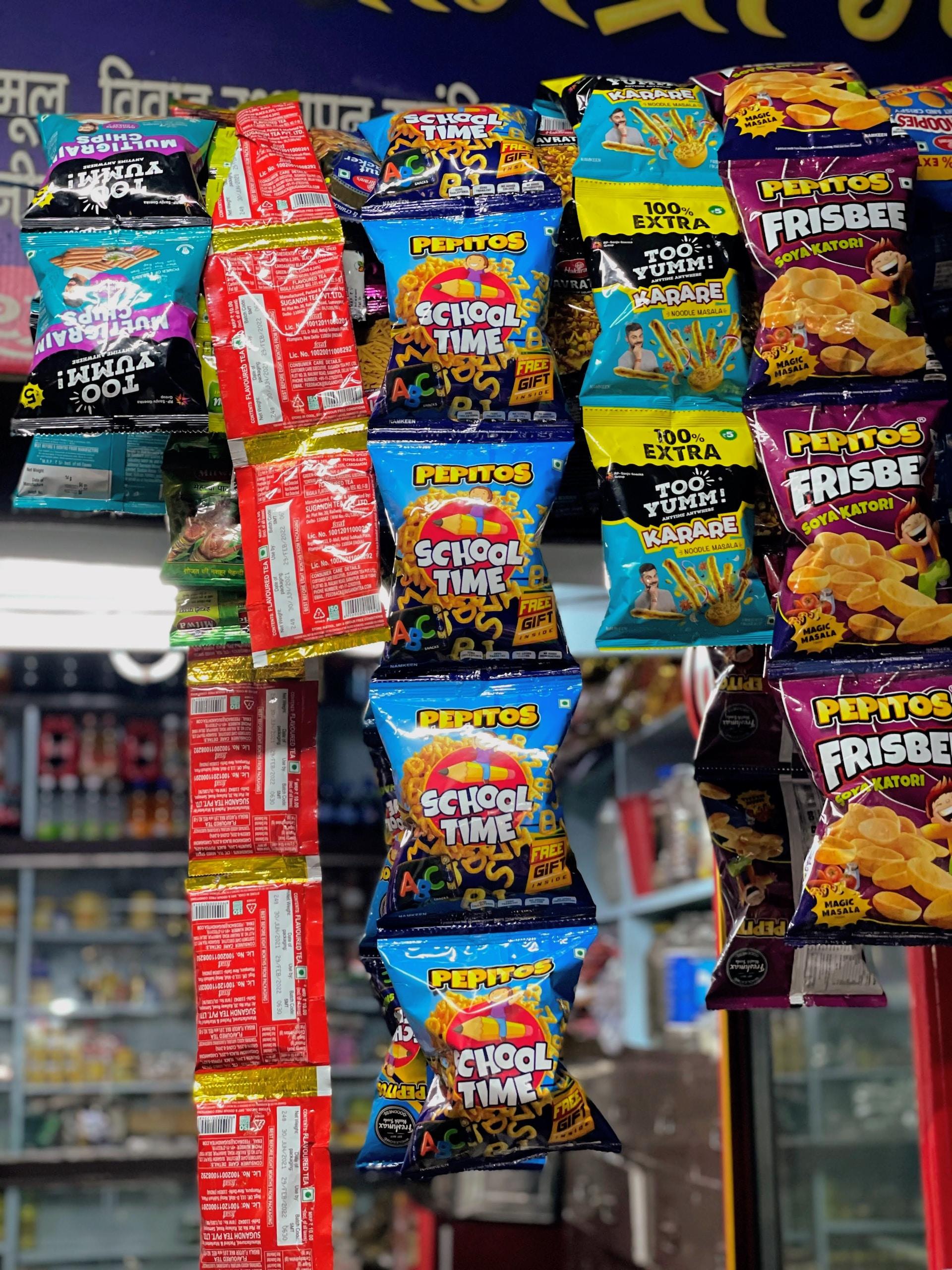 An array of brightly coloured packages of snacks hangs in a shop by the entrance.