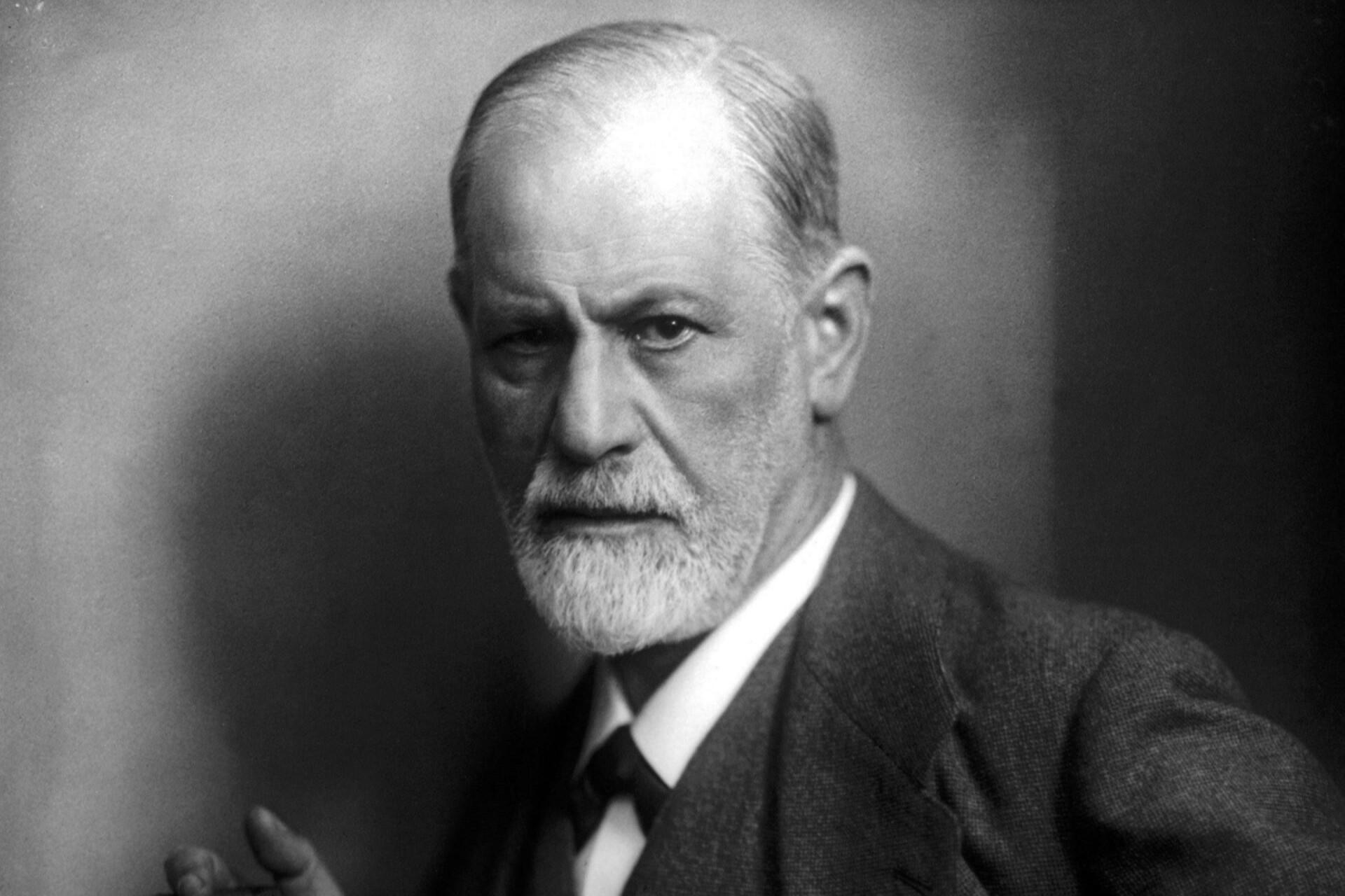 Black and white portrait of an older male psychologist (Sigmund Freud) with a serious expression.