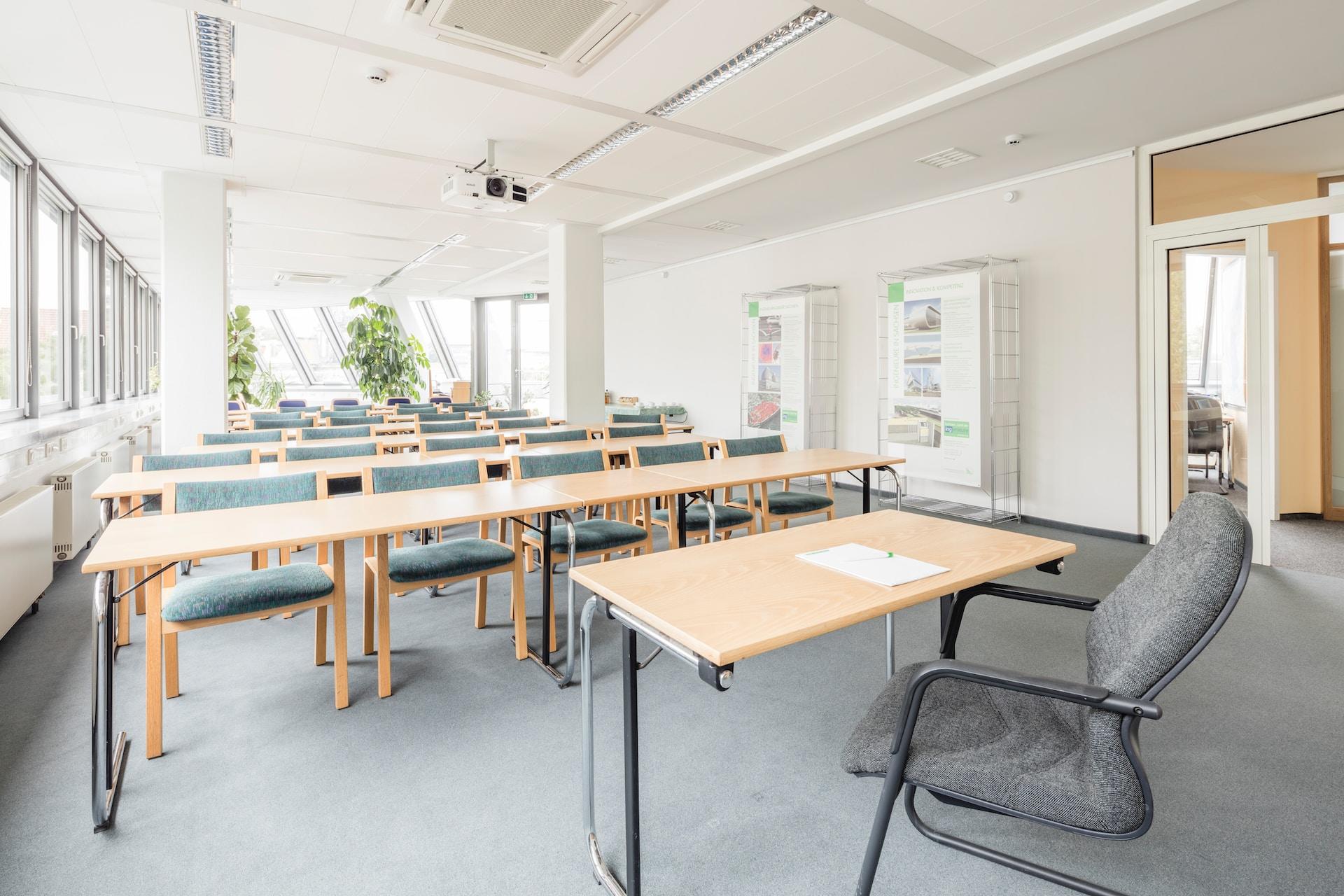 A light, airy learning space with creamy white walls and blond wood desks.